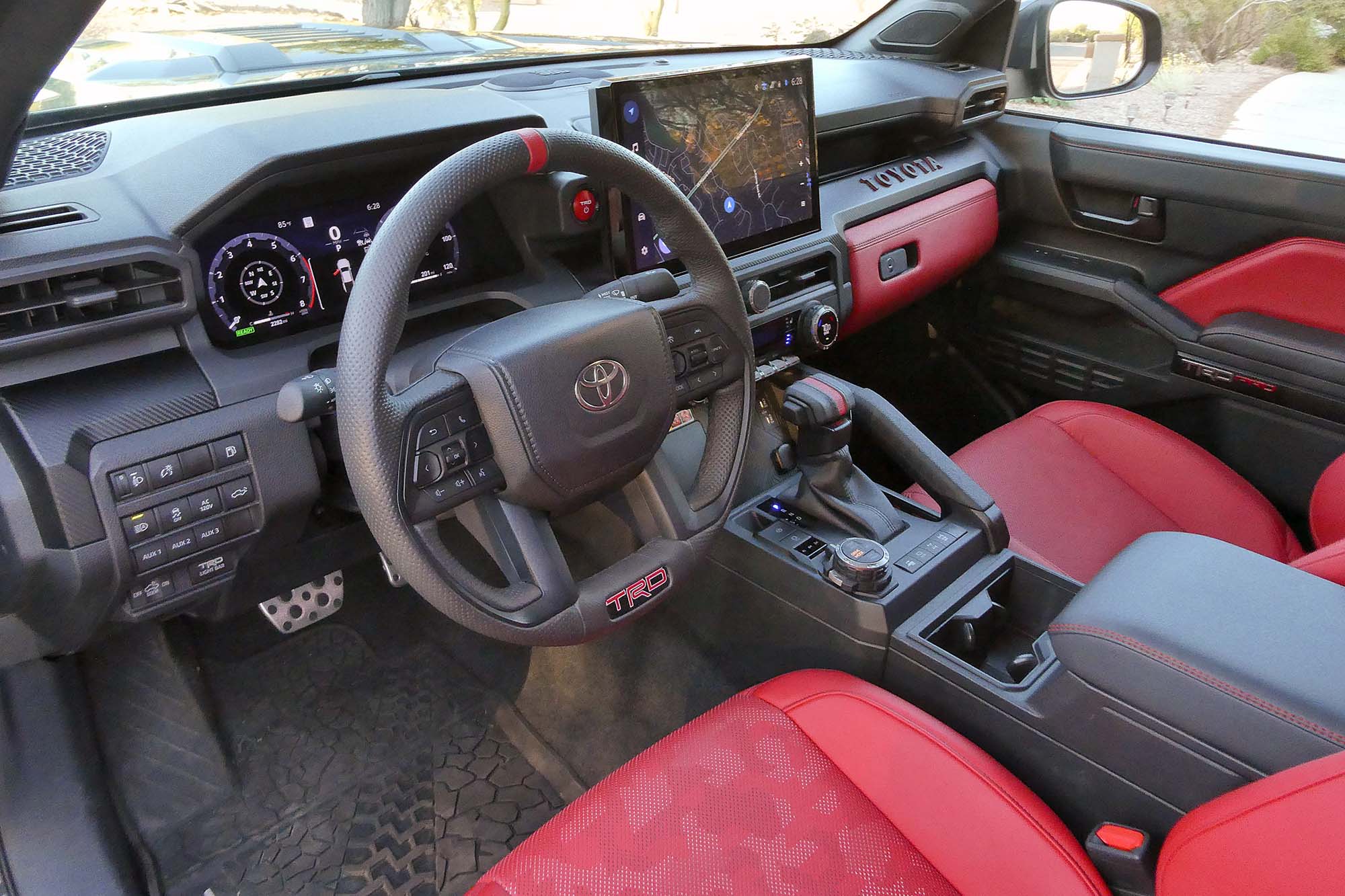 View of a 2024 Toyota Tacoma TRD Pro interior showing the dashboard and red front seats.