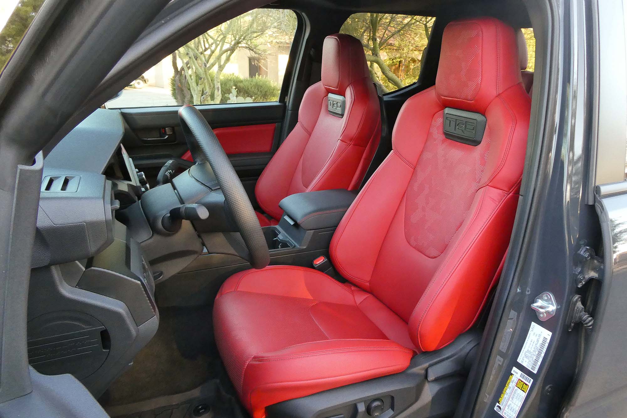 View of a 2024 Toyota Tacoma TRD Pro interior showing the Iso-Dynamic Performance front seats in red SofTex artificial leather.