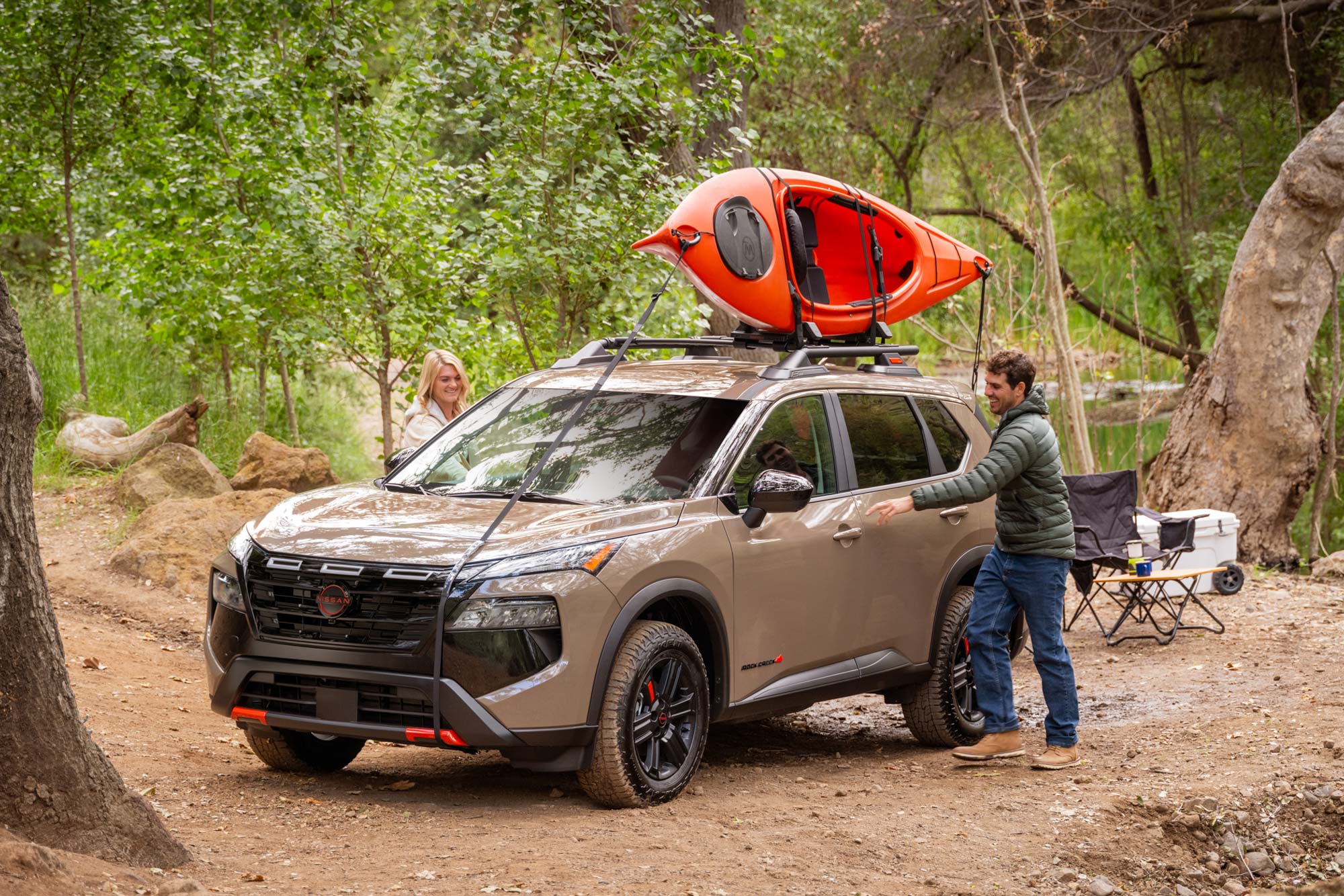 Front of a 2025 Nissan Rogue Rock Creek and two people about to open its front doors