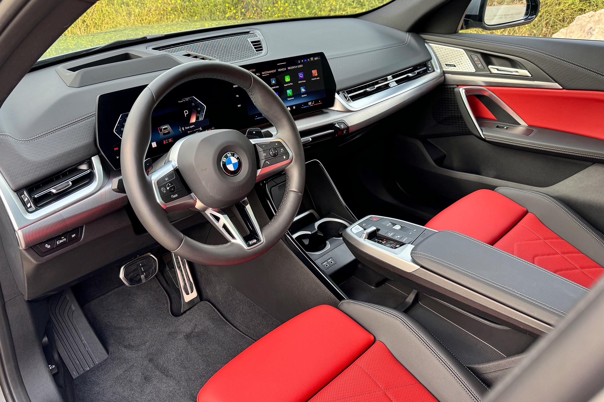 Front interior of a 2024 BMW X2 with red seat insets.