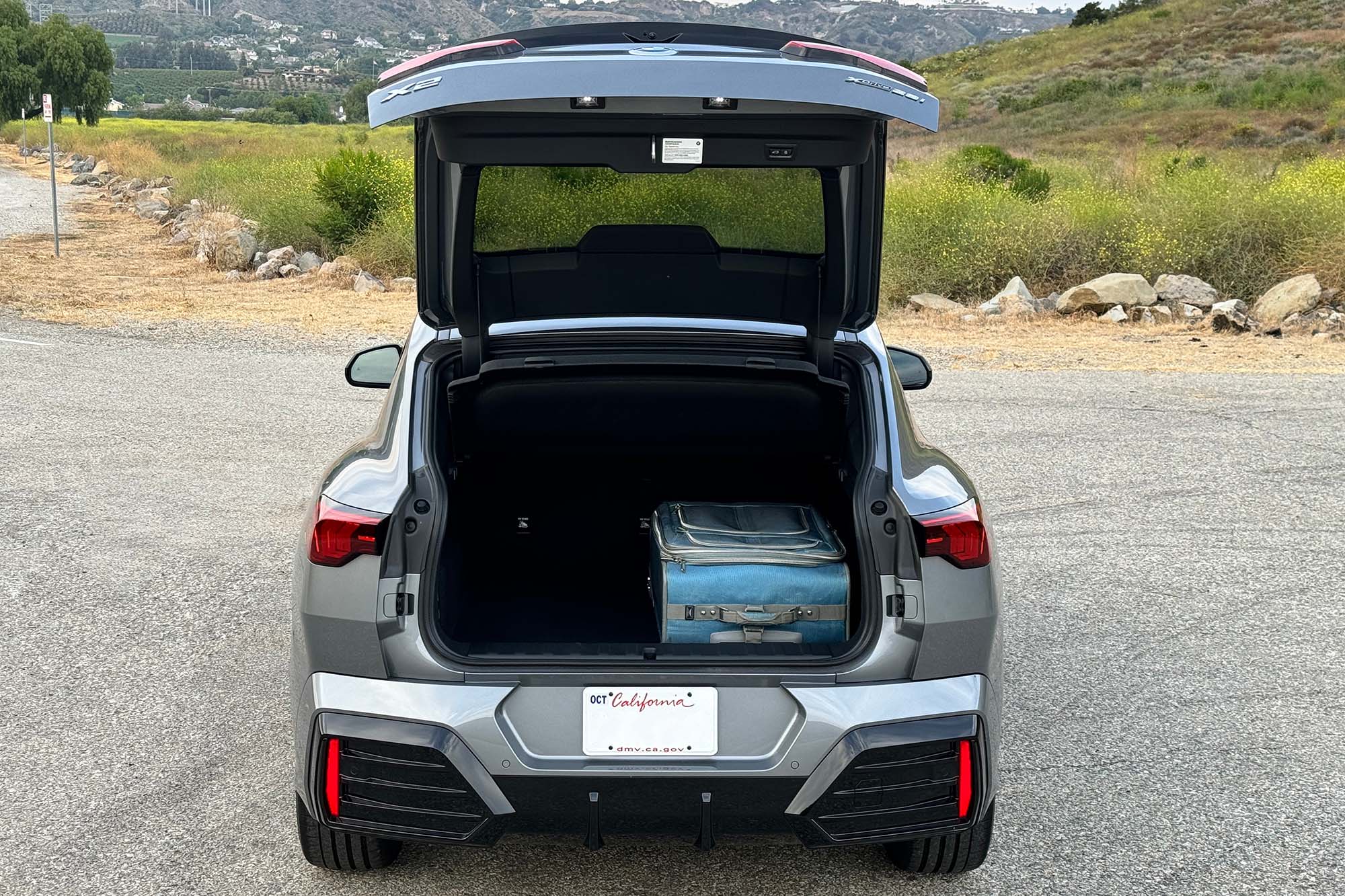 Gray 2024 BMW X2 cargo space with open trunk lid.