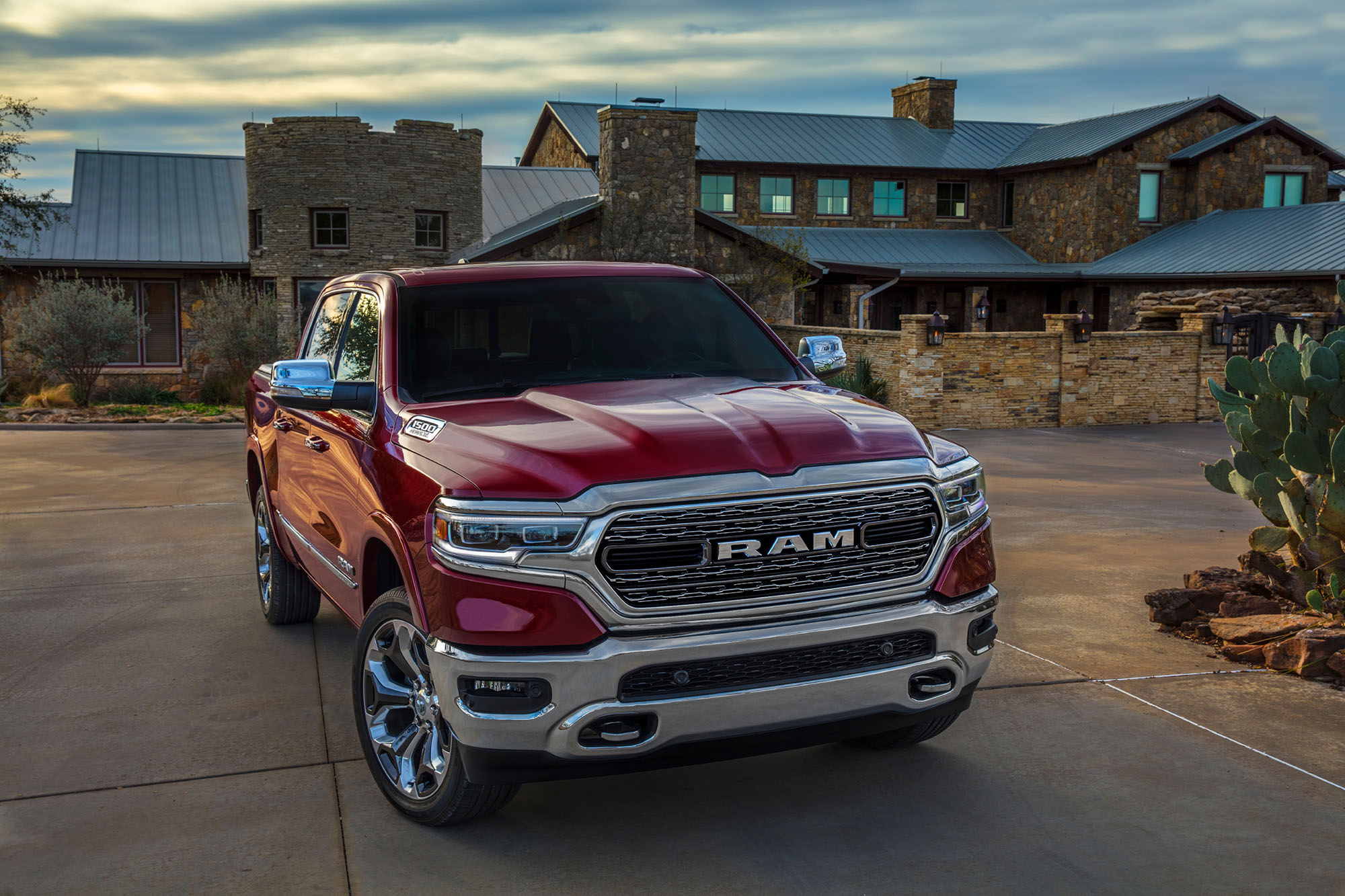 Red Ram 1500 truck parked in front of a large house.