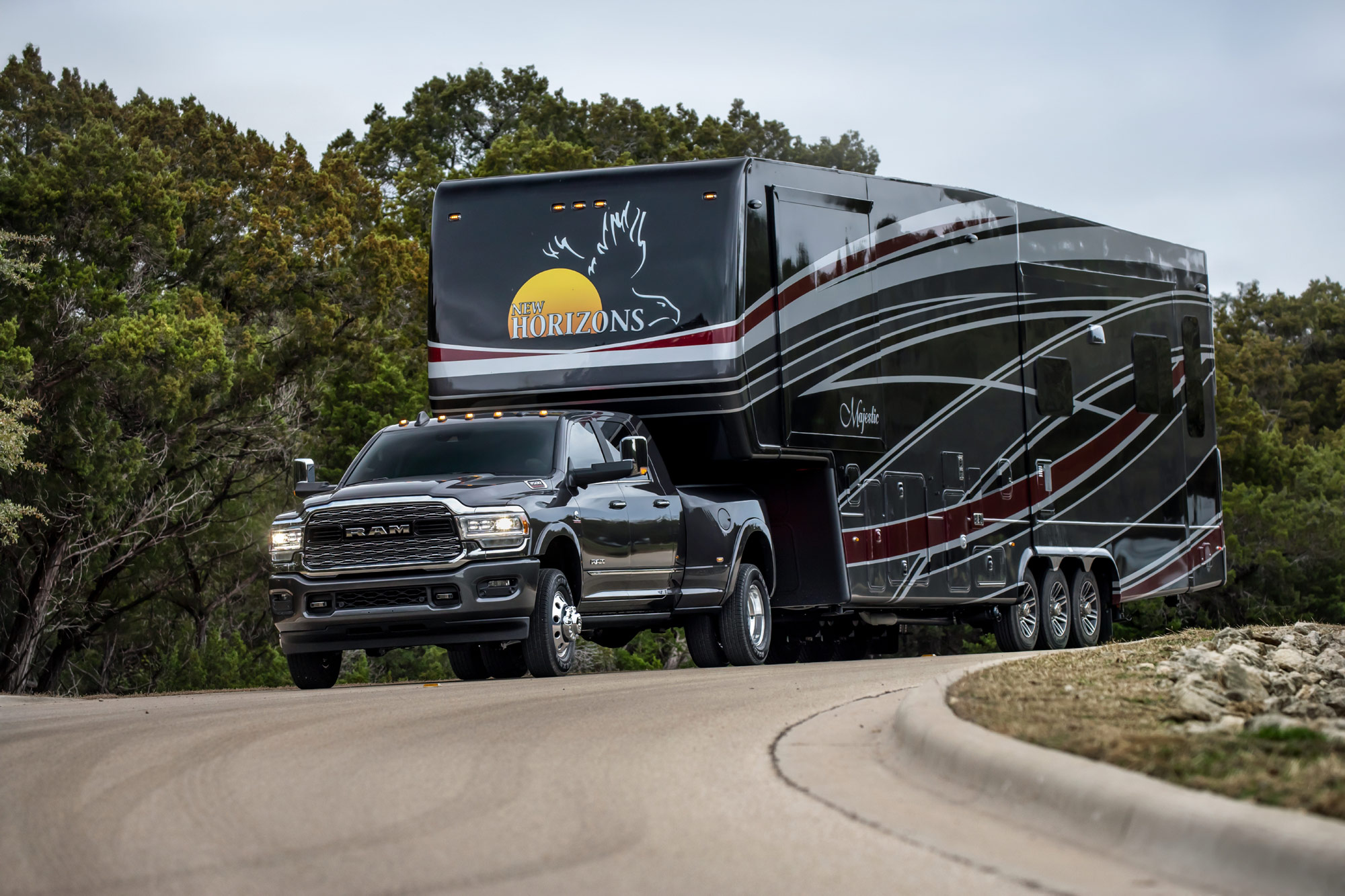 2024 Ram 3500HD Towing recreational trailer on road.