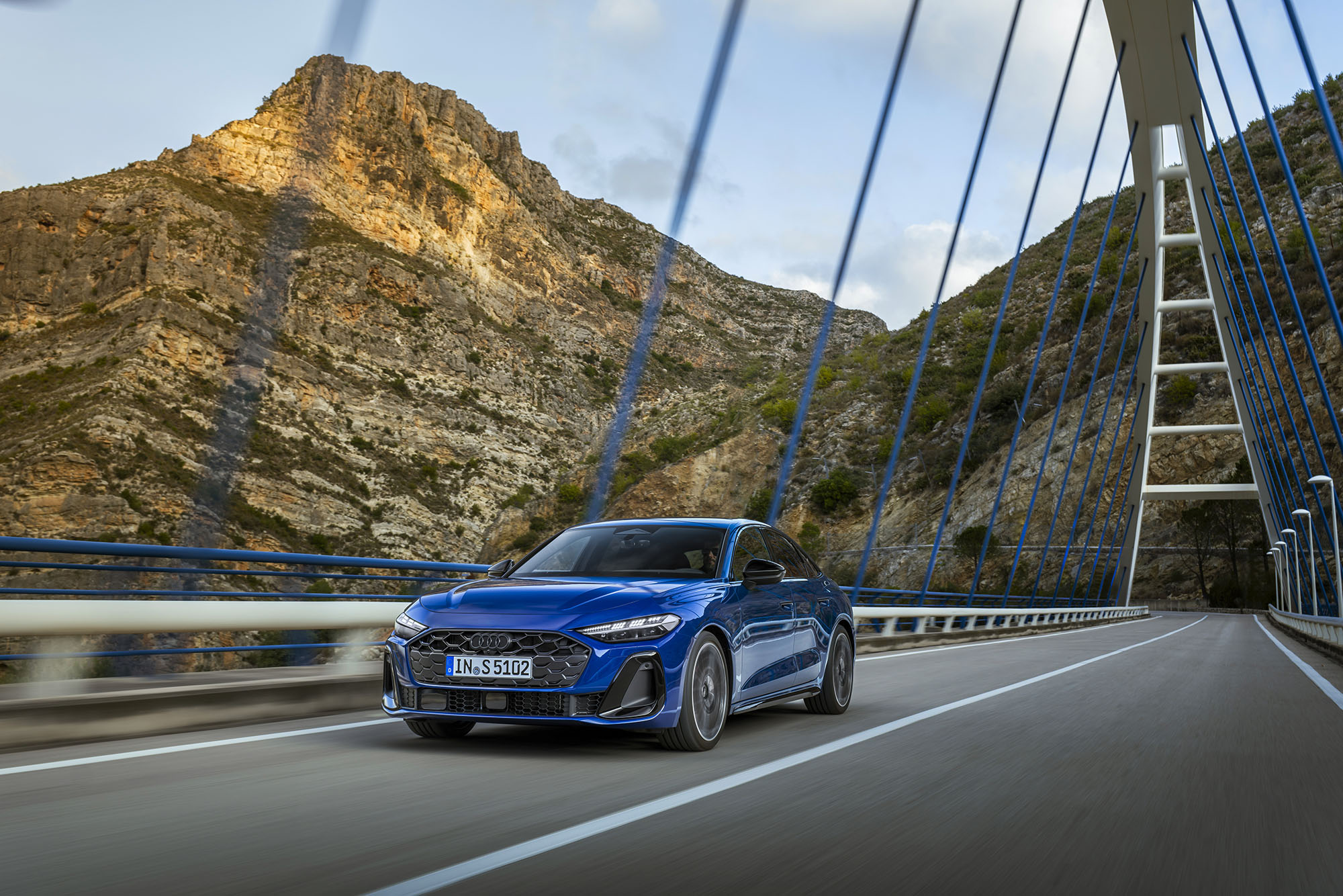 2025 Audi S5 Sedan in Ascari Blue Metallic driving on bridge