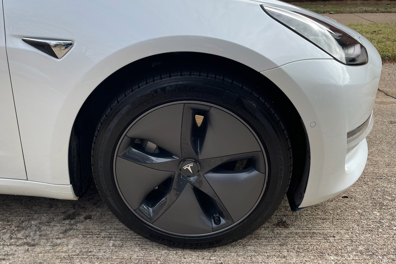 Tesla Model 3 with the older design of aero wheel covers.