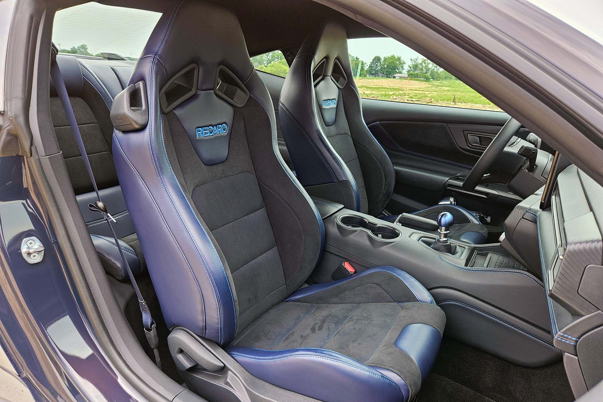 View of a 2024 Ford Mustang Dark Horse interior showing the Recaro front performance seats, taken from the passenger's side of the car.