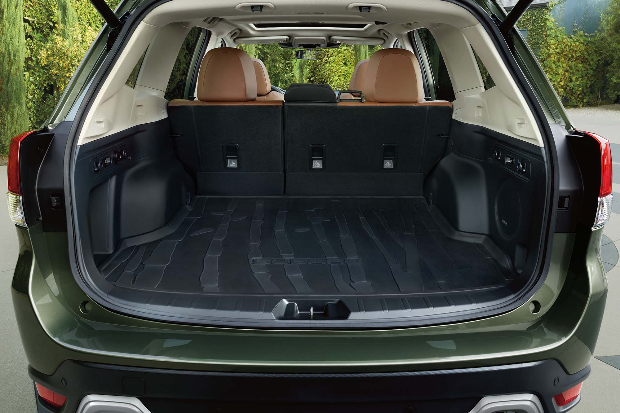 Cargo space with open liftgate on a green Subaru Forester.