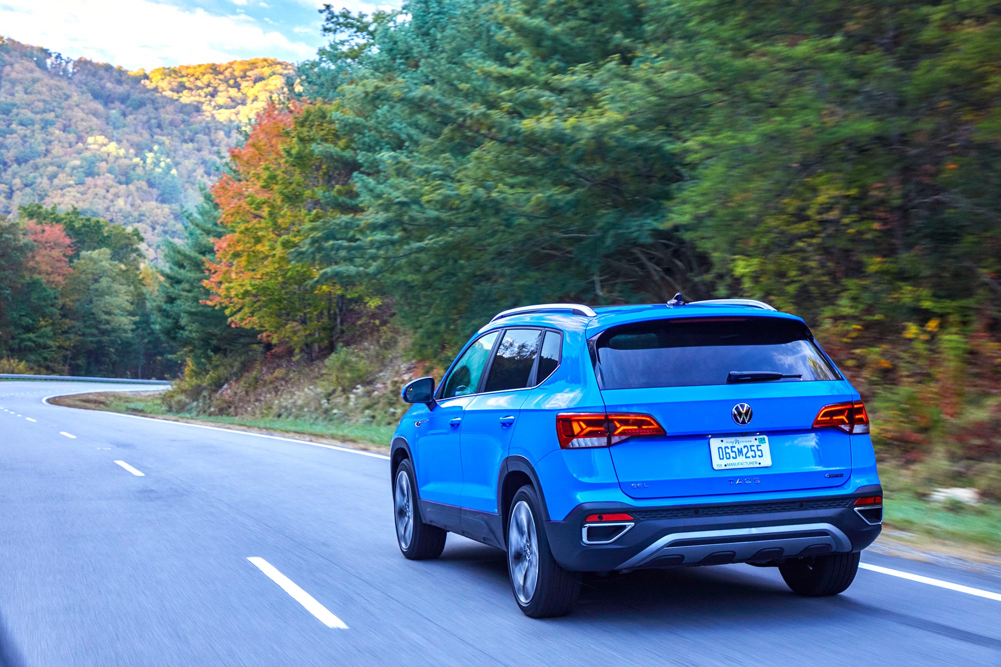 2024 Volkswagen Taos driving down a scenic highway