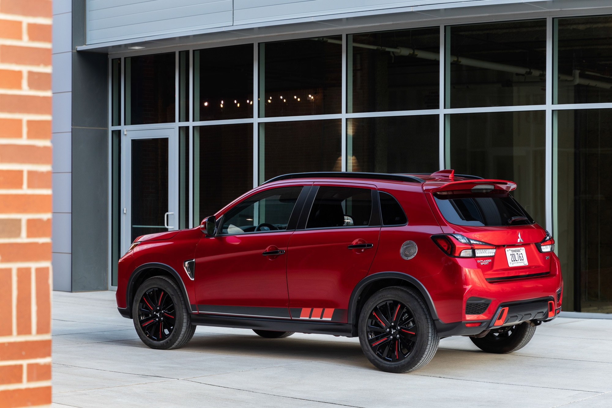 Red 2024 Mitsubishi Outlander Sport parked by a building