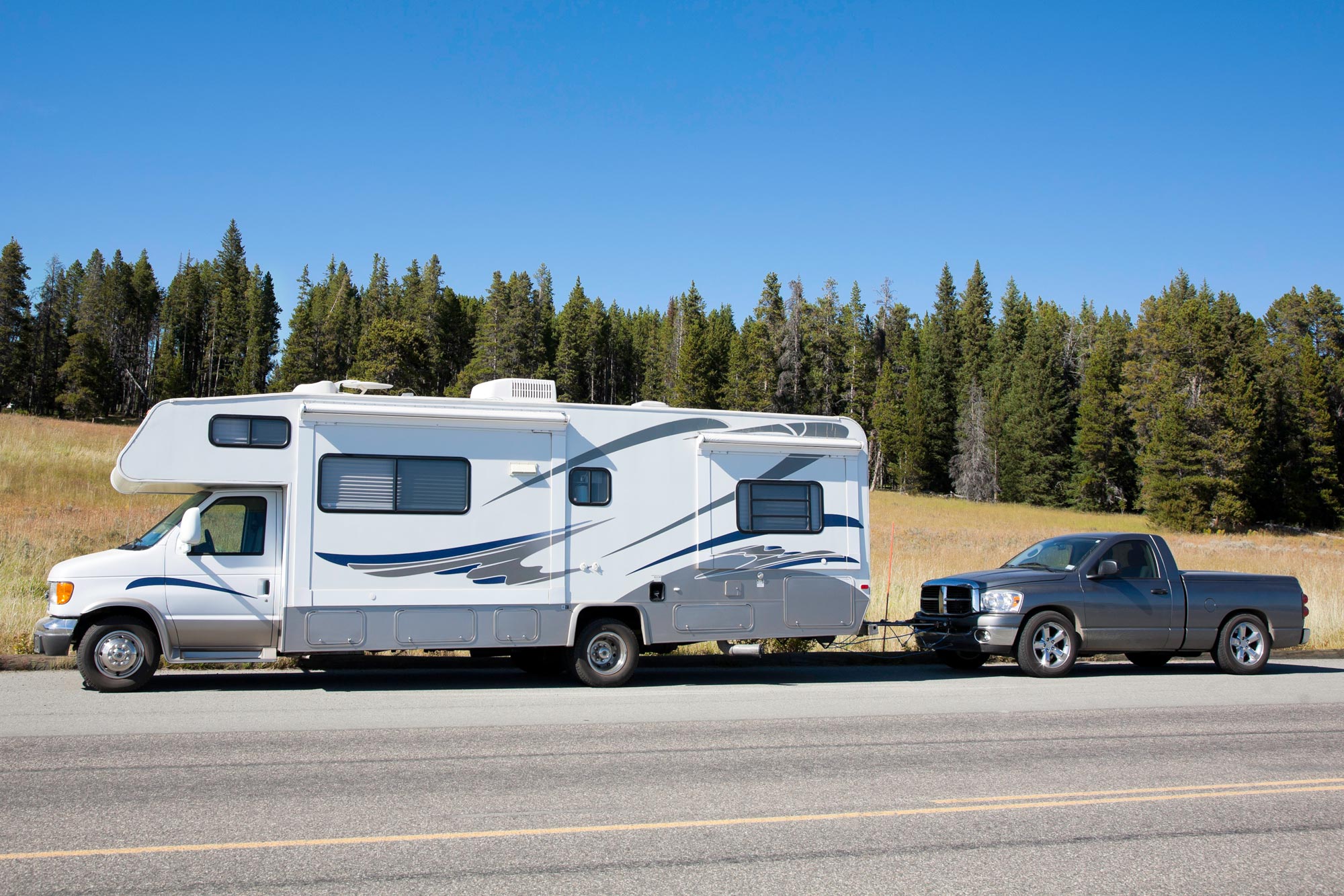 Recreational vehicles flat-towing a pickup truck.