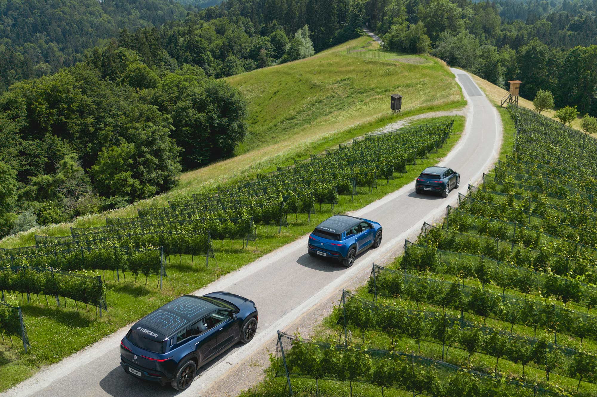 Three Fisker Ocean SUVs driving down mountainside