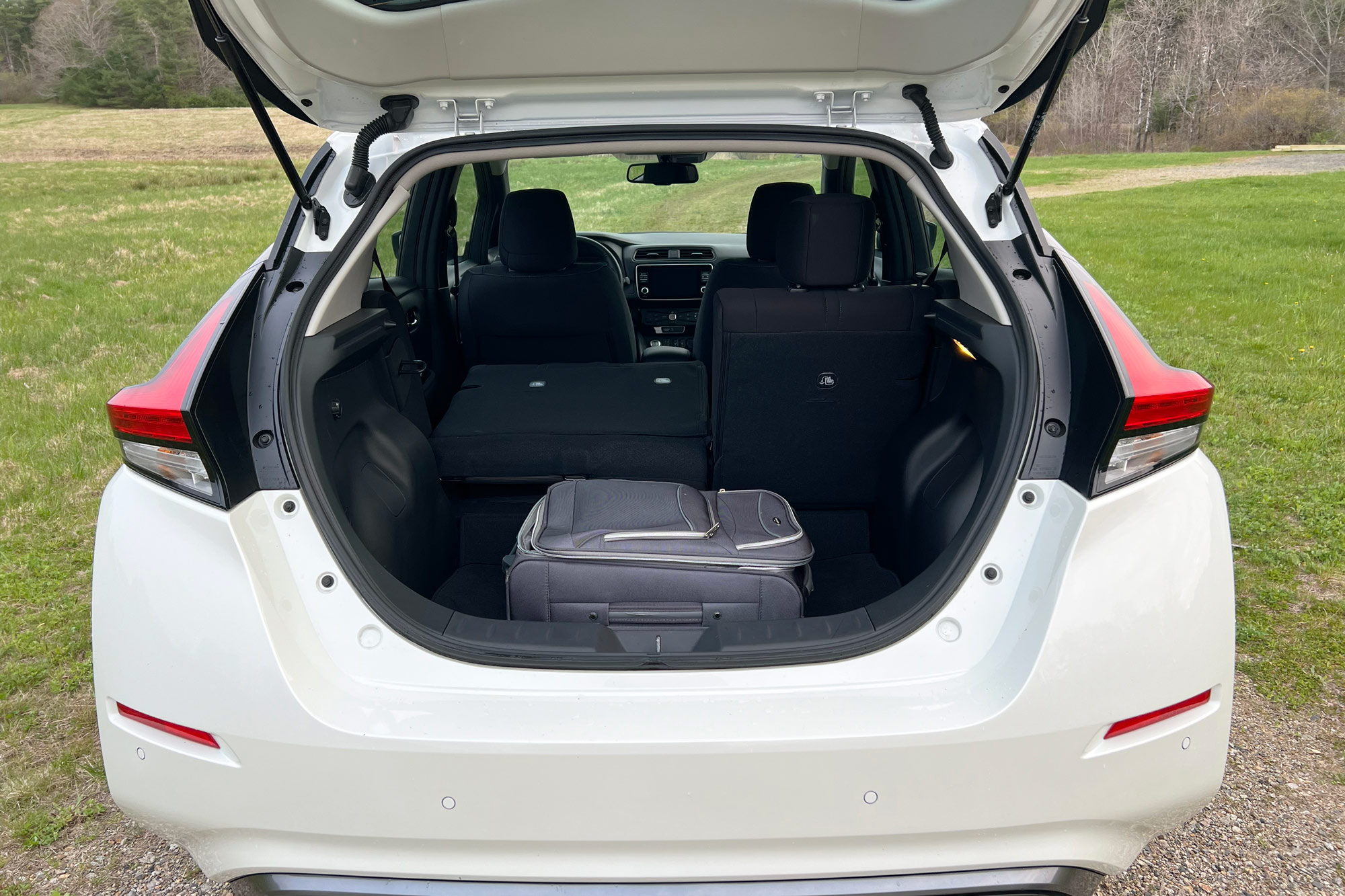 2024 Nissan Leaf SV Plus interior and cargo area with a roll-aboard-sized suitcase stored inside