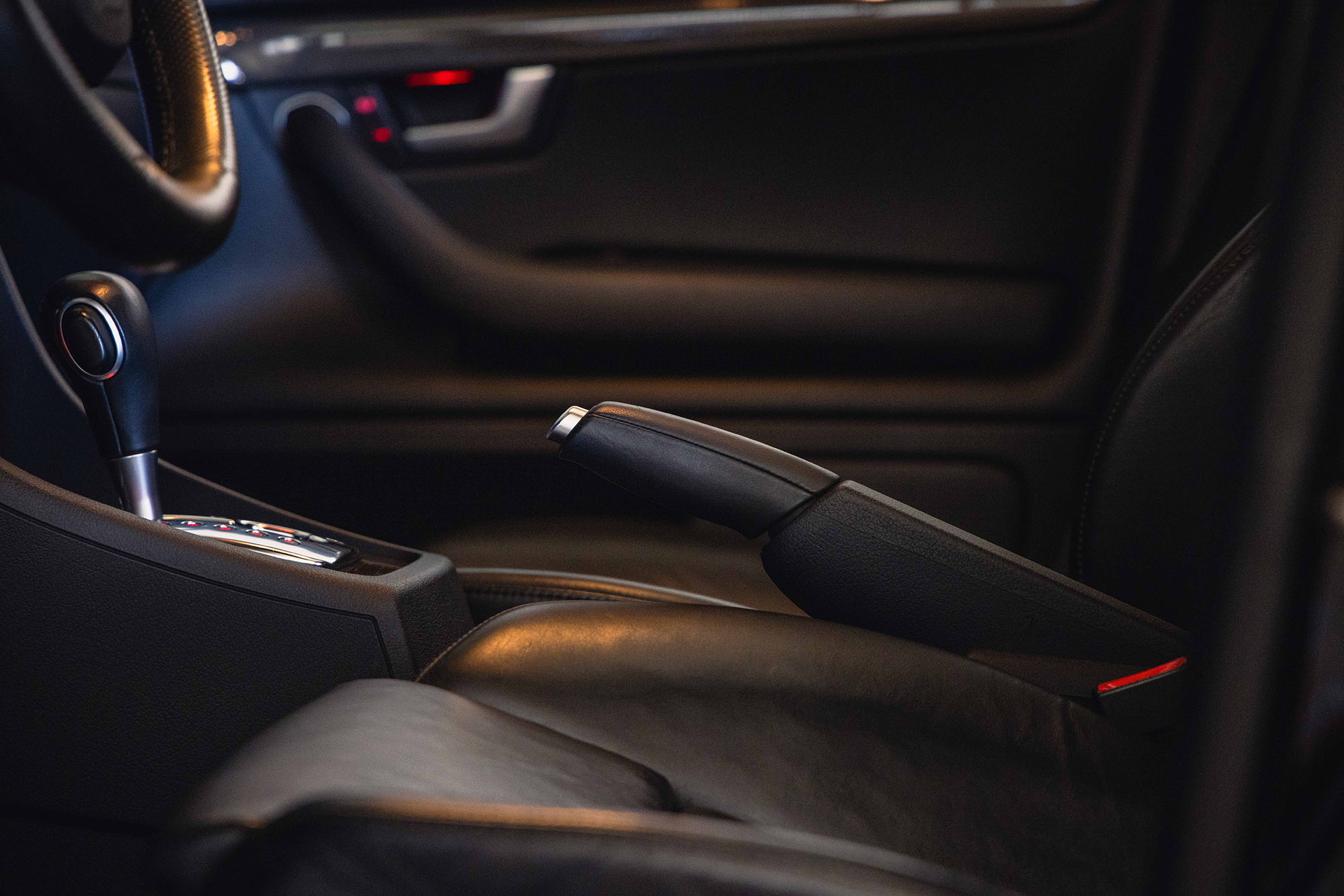 Front seat of a vehicle with the parking brake lever engaged.