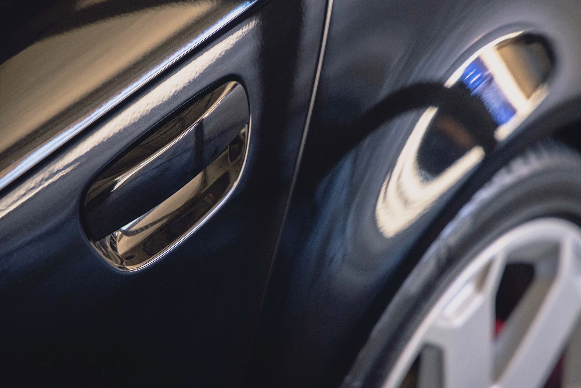 Car exterior with a hinged door handle.