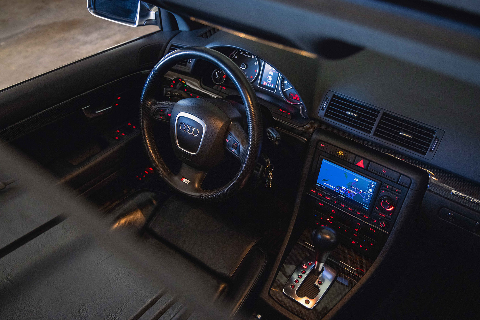 Interior of a car with a small infotainment screen, key fob, and gear shift knob.