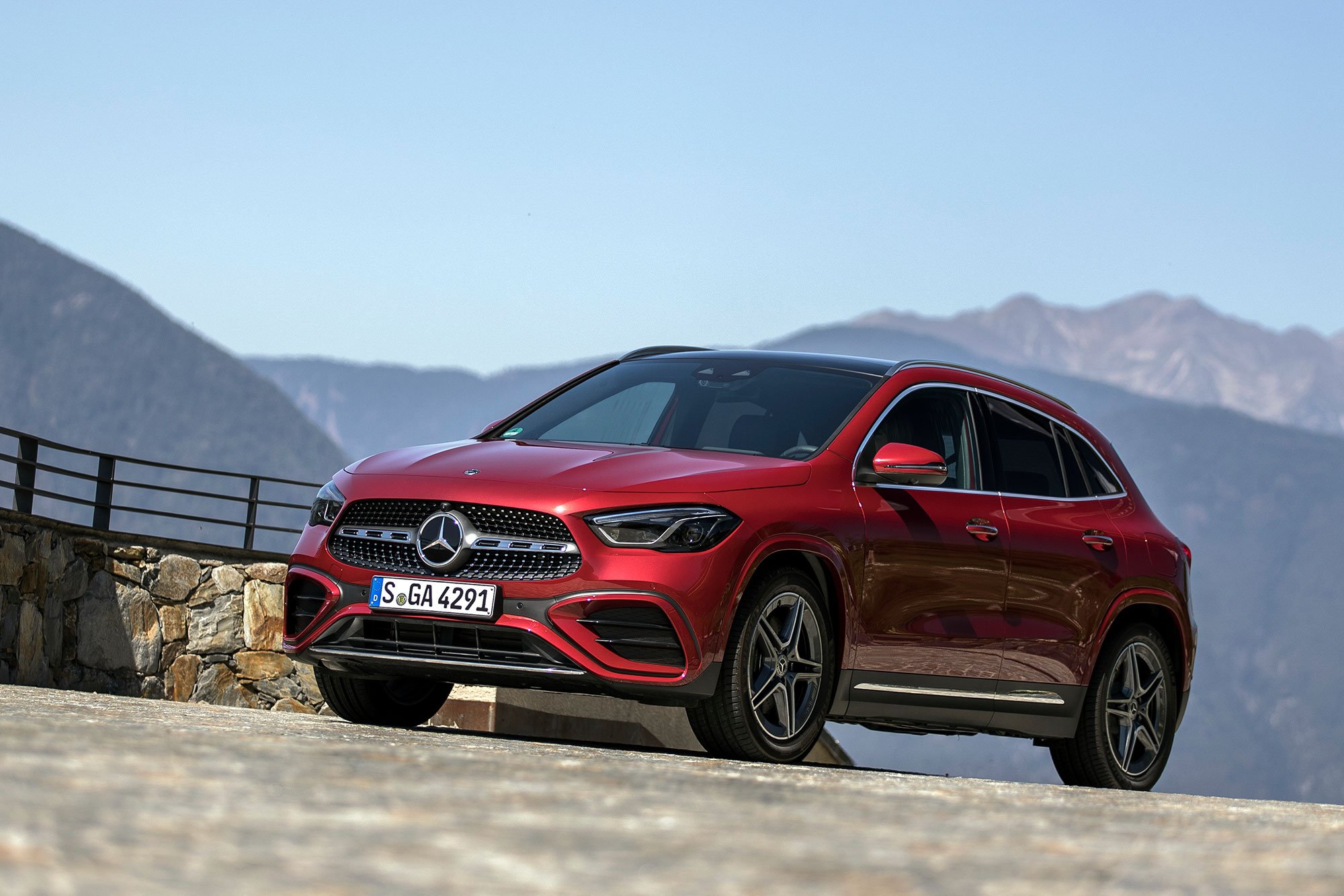 Red Mercedes-Benz GLA parked at a mountain overlook.