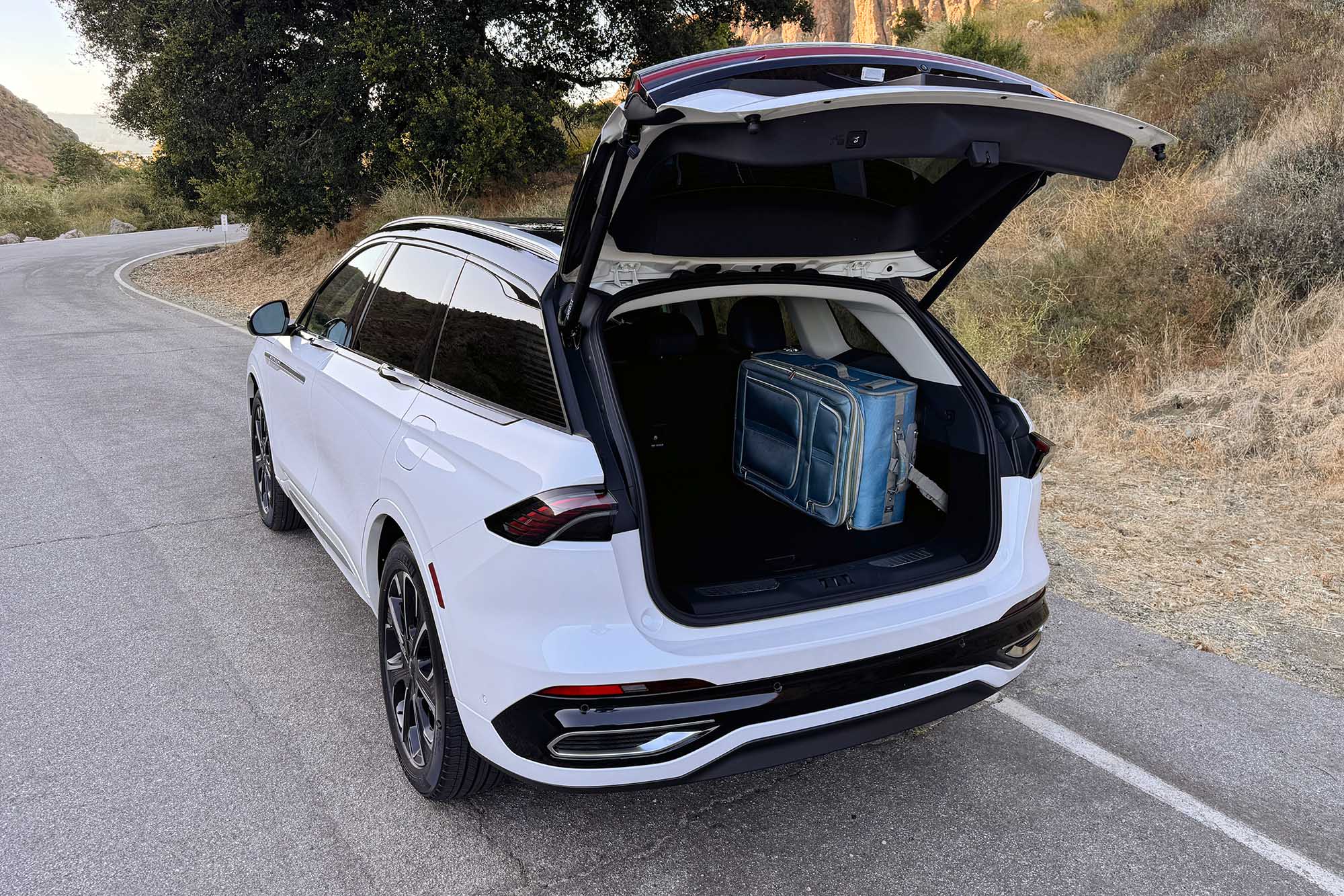 View of a 2024 Lincoln Nautilus showing the cargo space with a blue full-size suitcase loaded into the trunk on its side.