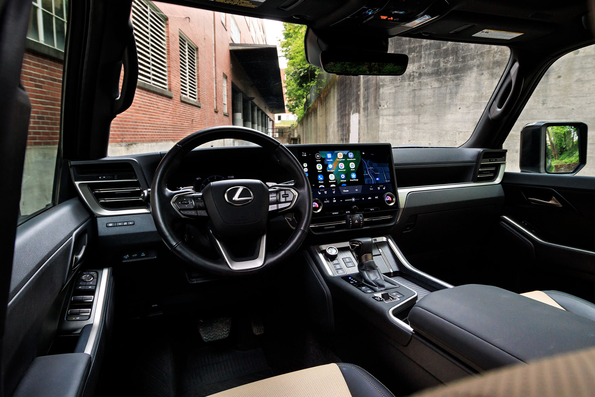 View of a 2024 Lexus GX Overtrail interior showing the dashboard with an alley visible through the windshield.