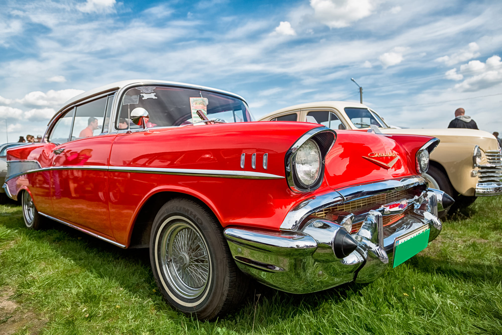 Red vintage 1957 Chevrolet Bel Air at an outdoor car show