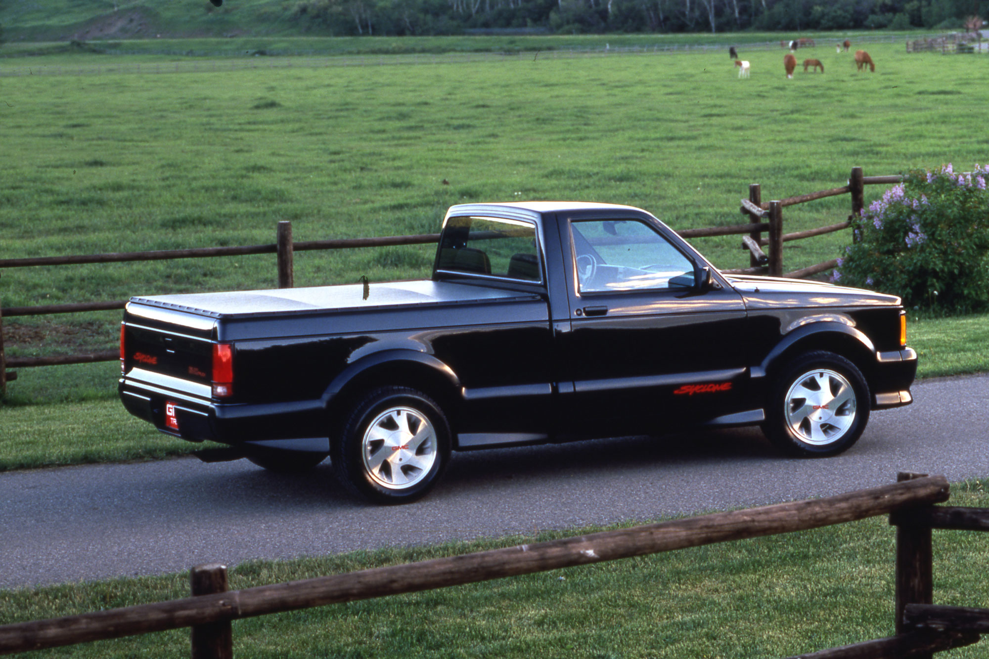 1991 GMC Syclone parked on pavement by a pasture.