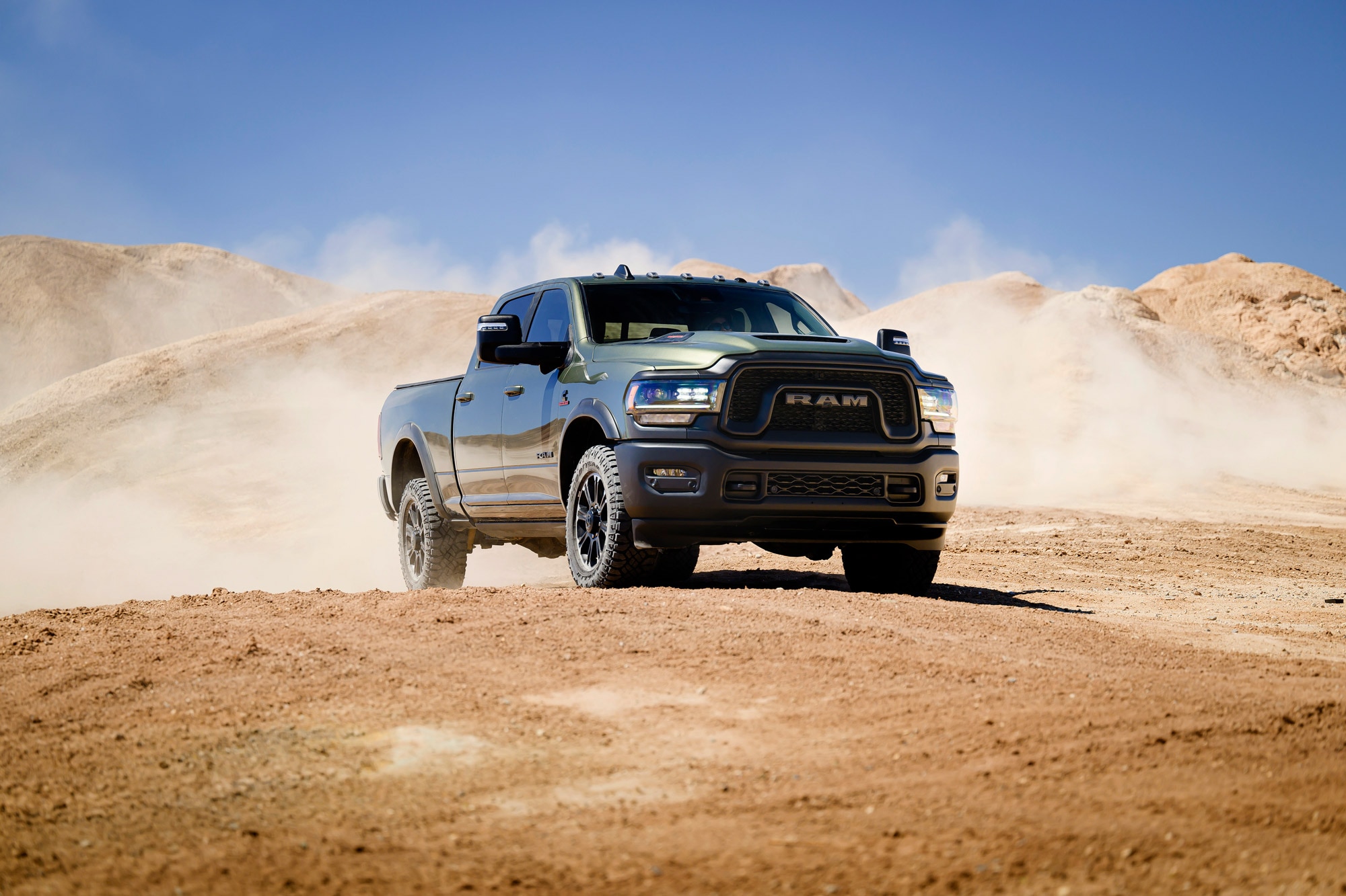 2024 Ram 2500 parked on dirt with some dust in the background.