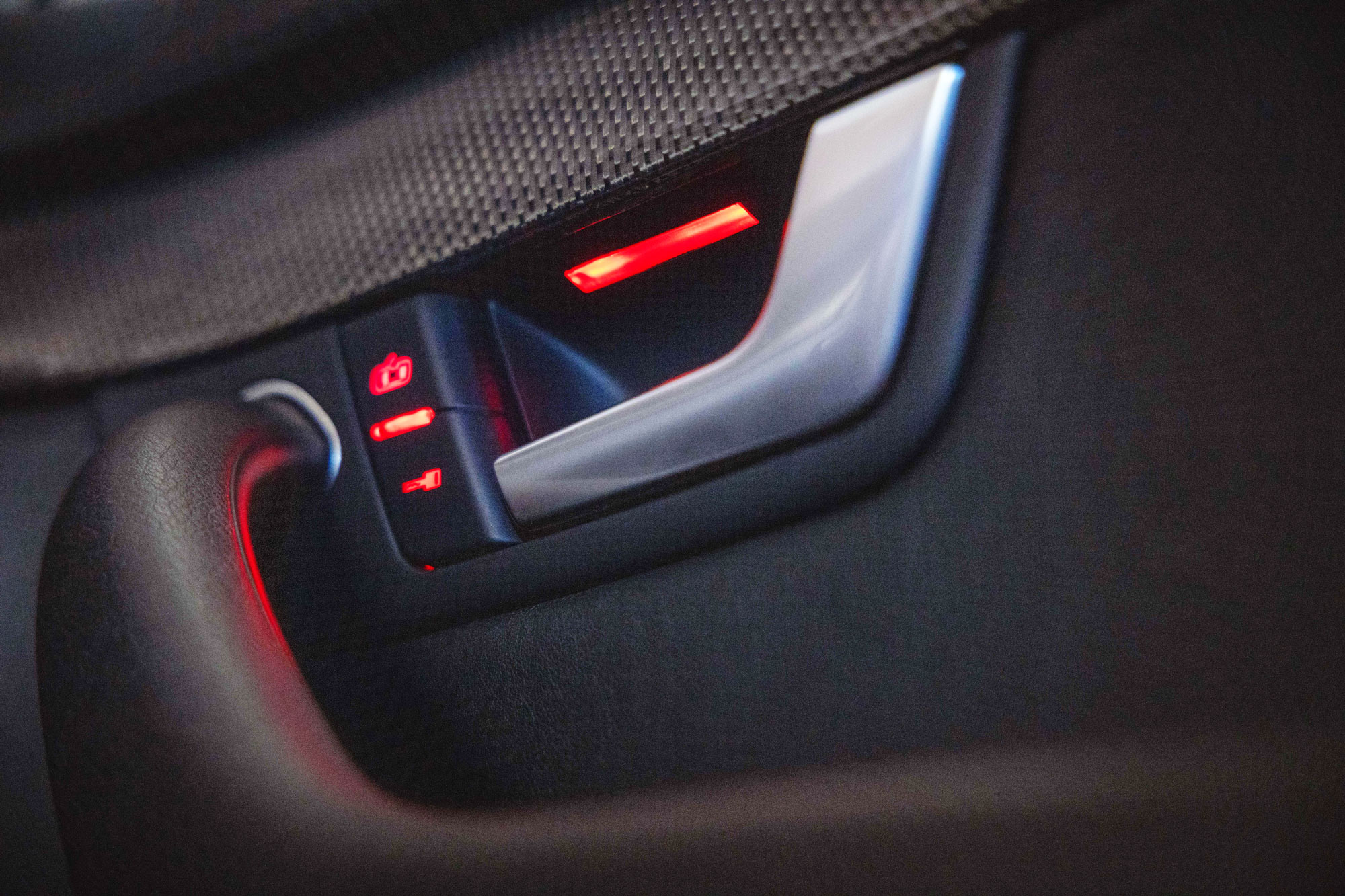 Close-up of car with illuminated LED behind door handle and lock buttons.