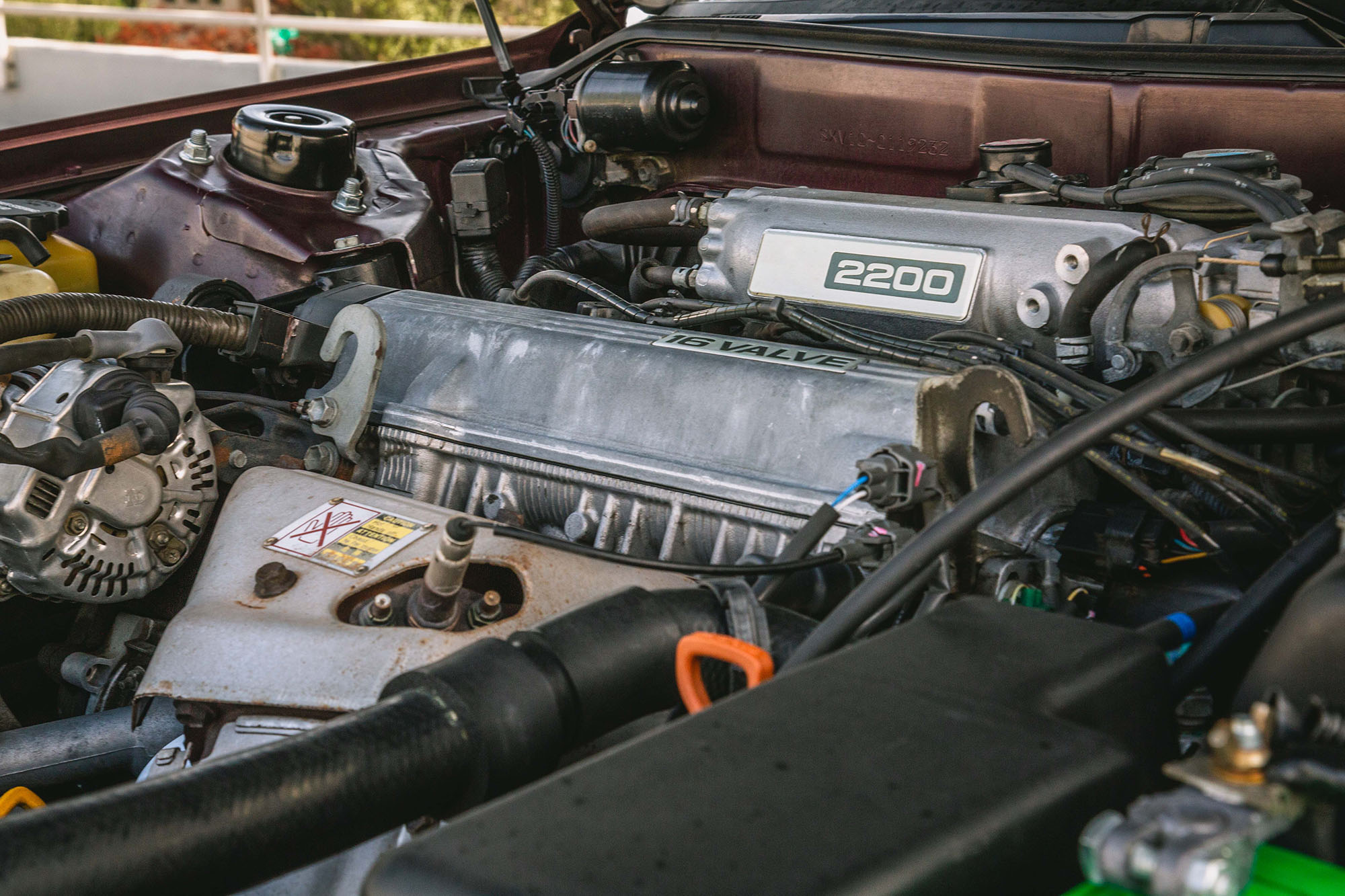 Vehicle engine bay beneath an open car hood.