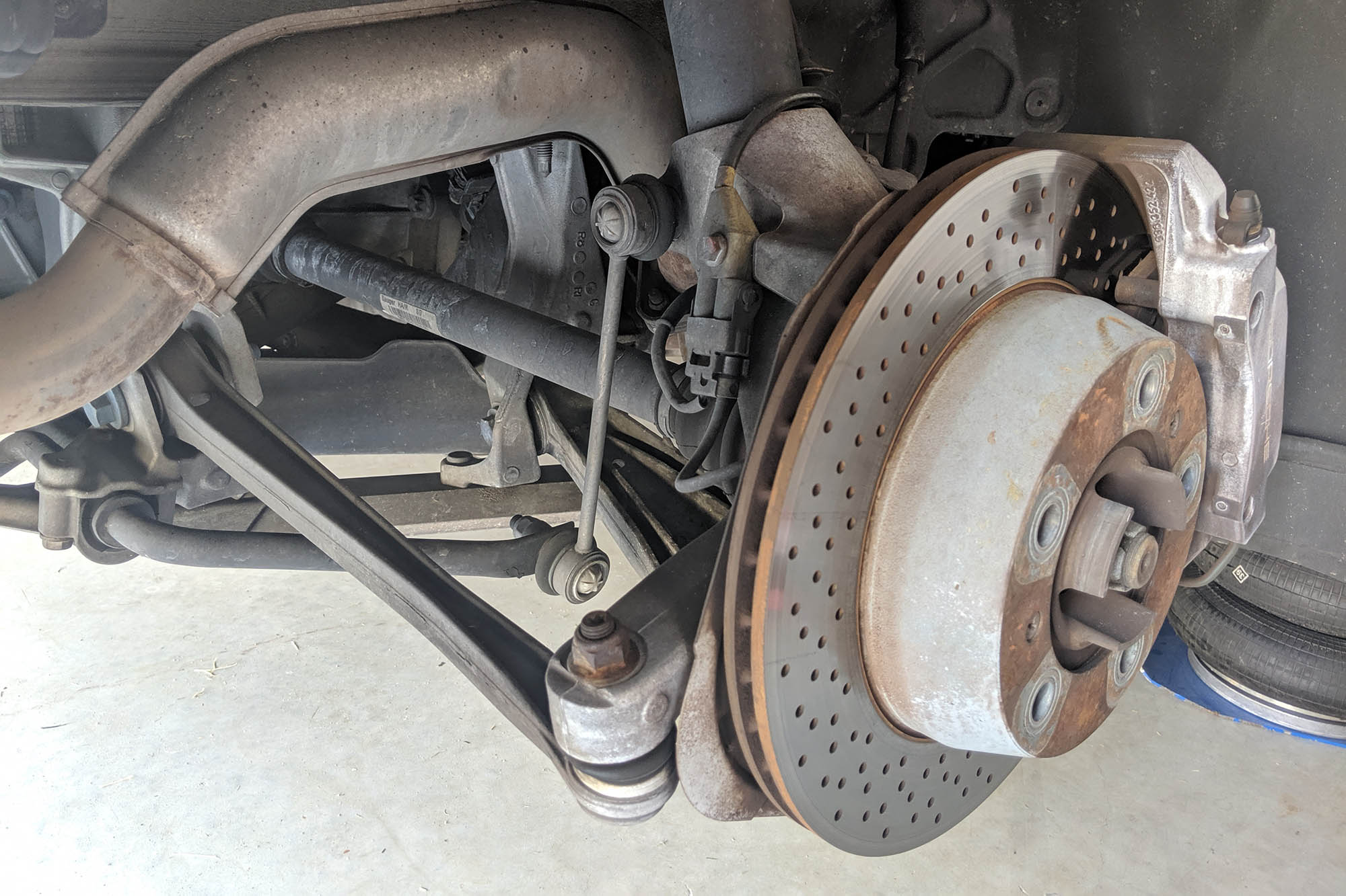 Suspension parts on a vehicle without a wheel or tire.