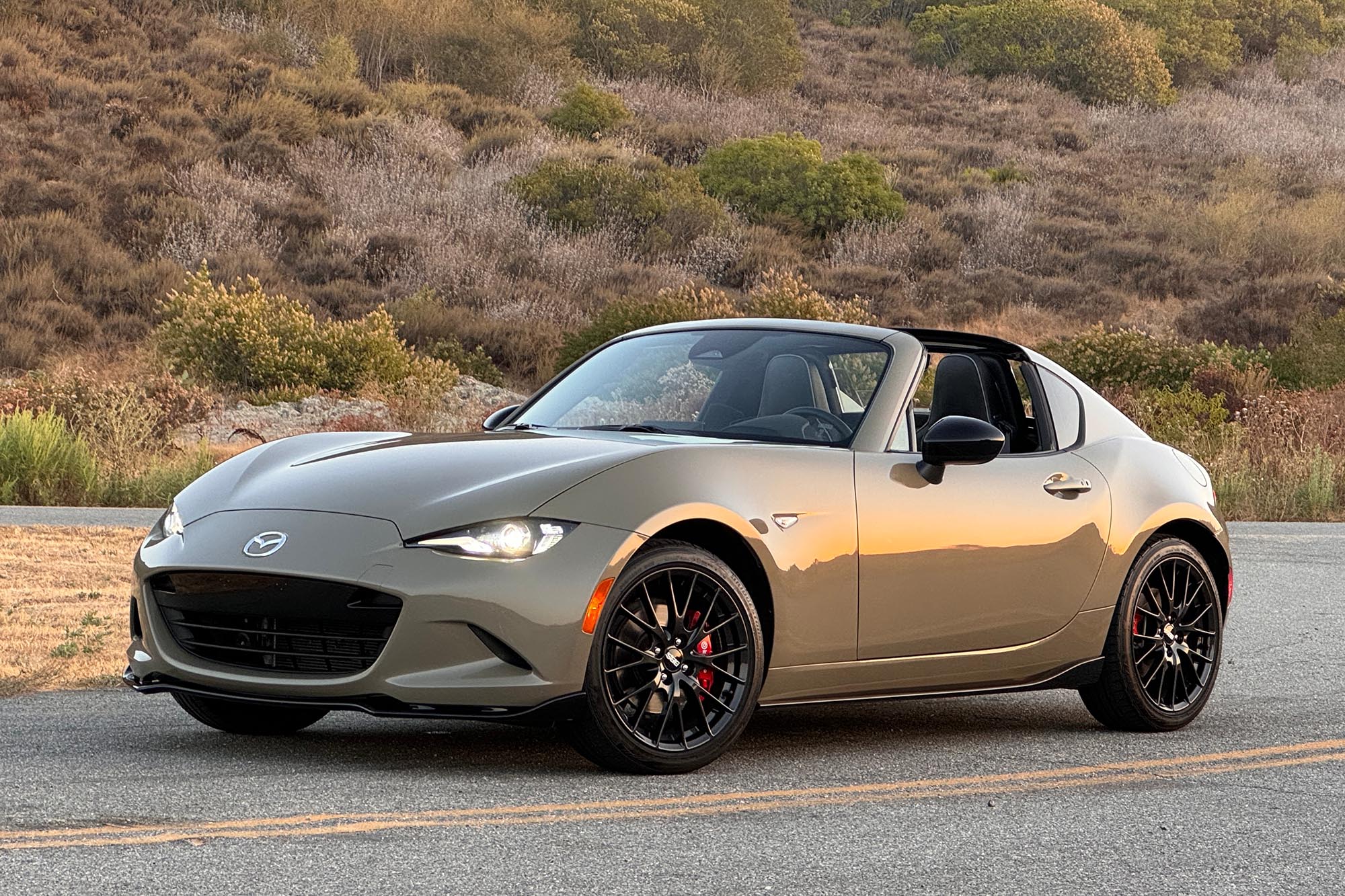 2024 Mazda MX-5 Miata RF Club in Zircon Sand, parked on a road at sunset.