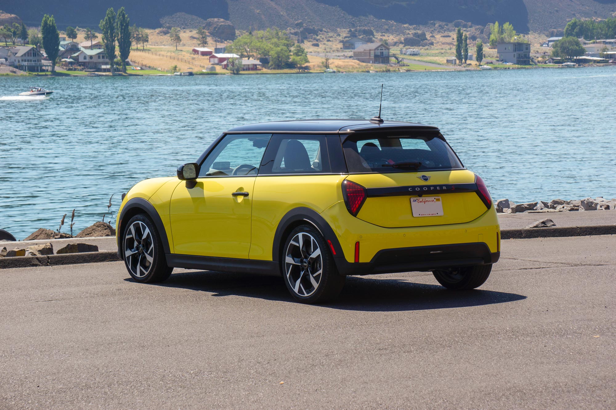 Yellow 2025 Mini Cooper parked by a river.