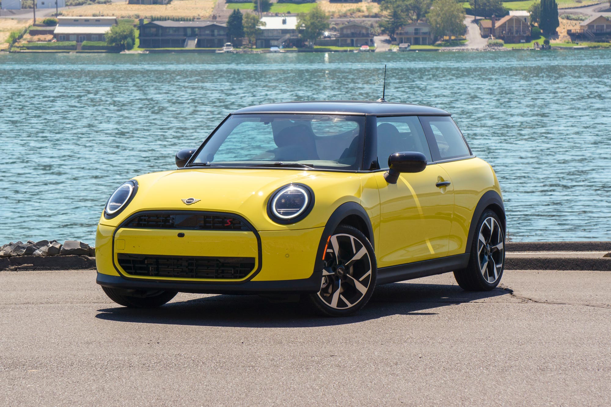 Yellow 2025 Mini Cooper parked by a river.