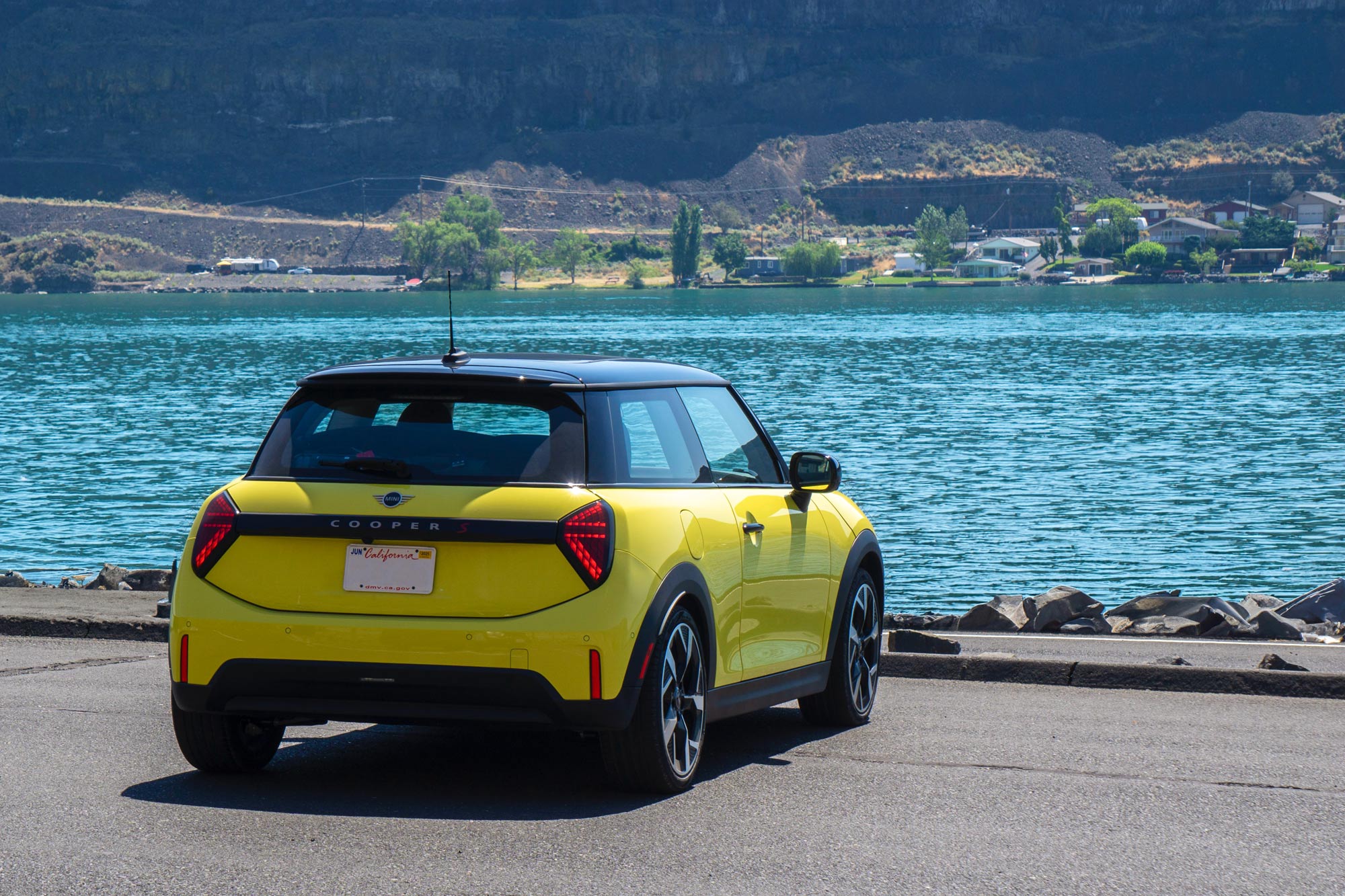 Yellow 2025 Mini Cooper parked by a river.