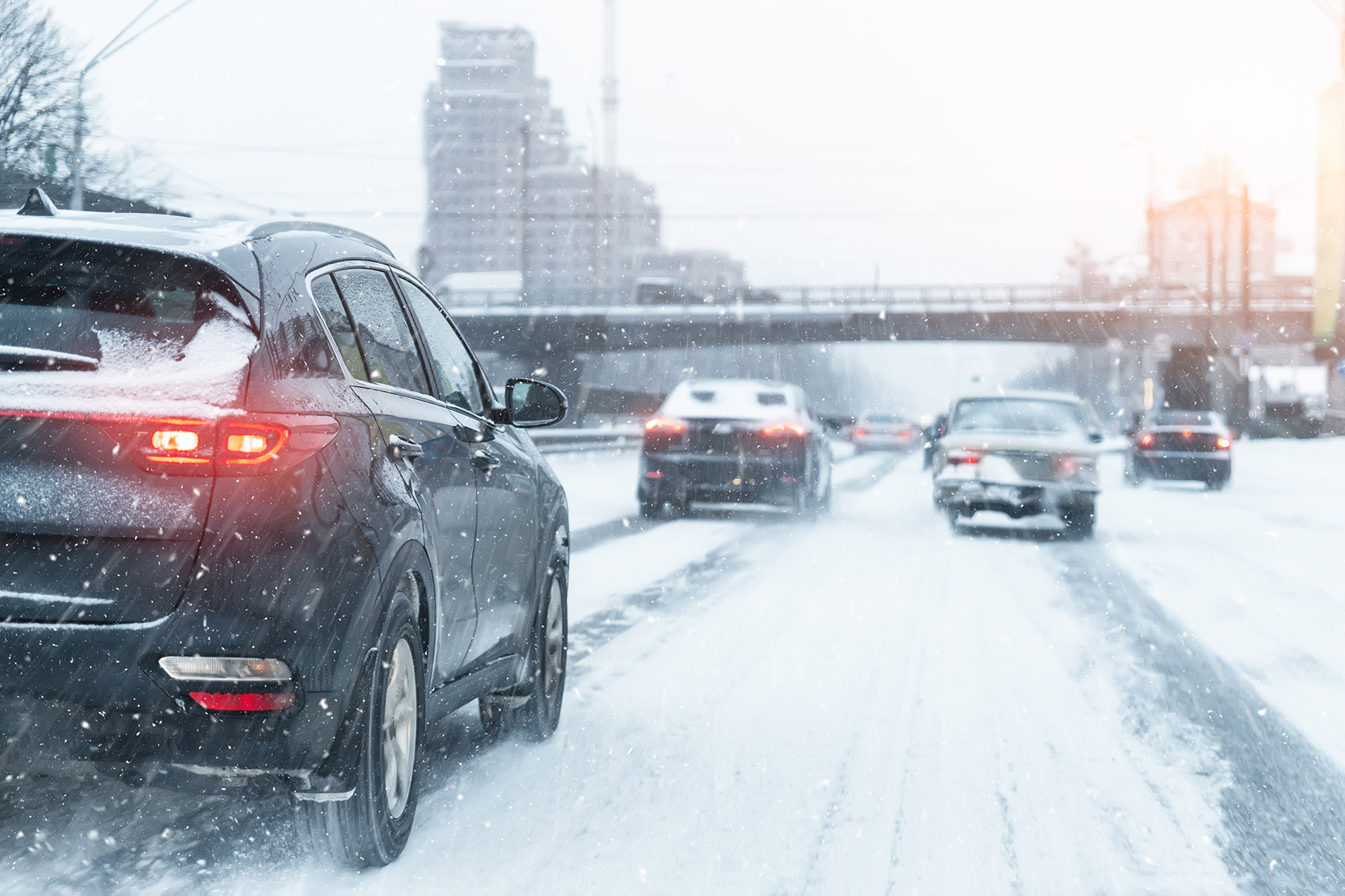 Cars drive on a snowy highway in winter.