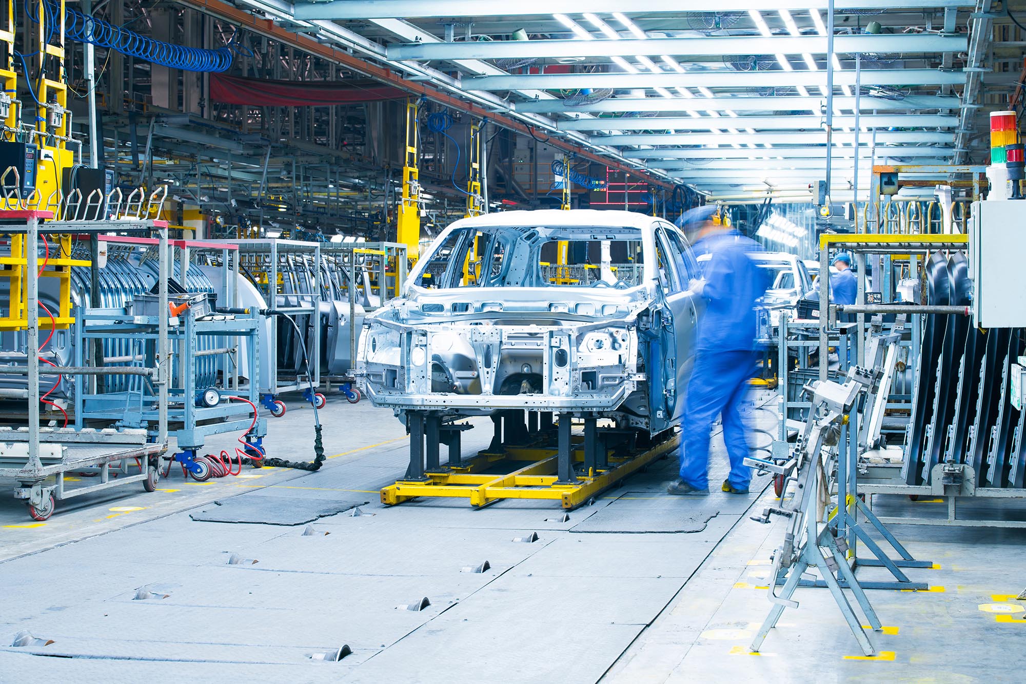 Workers assemble a car in a manufacturing plant.