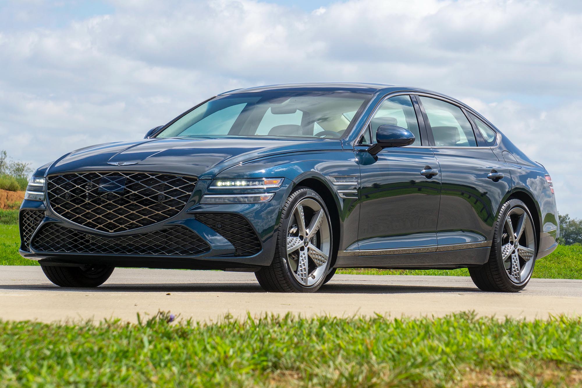 2025 Genesis G80 3.5T Sport Prestige in Tasman Blue with clouds and a faintly blue sky in the background