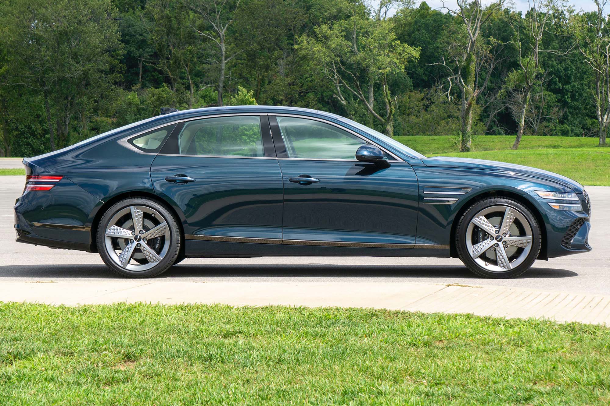 2025 Genesis G80 3.5T Sport Prestige in Tasman Blue with trees in the background