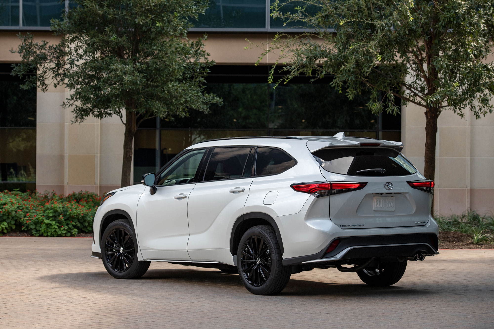 2024 Toyota Highlander parked by a building.