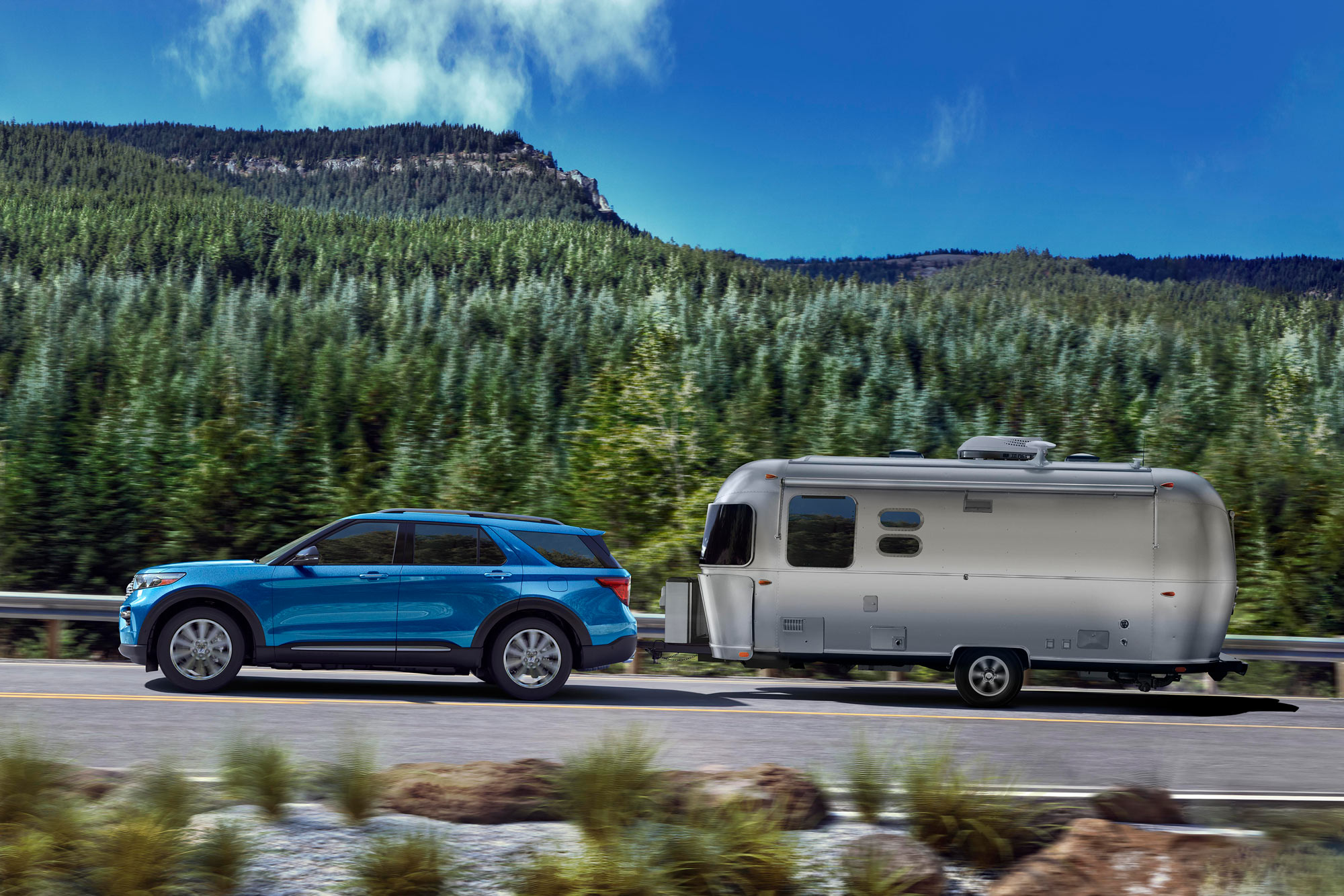 2024 Ford Explorer towing a trailer on a highway.