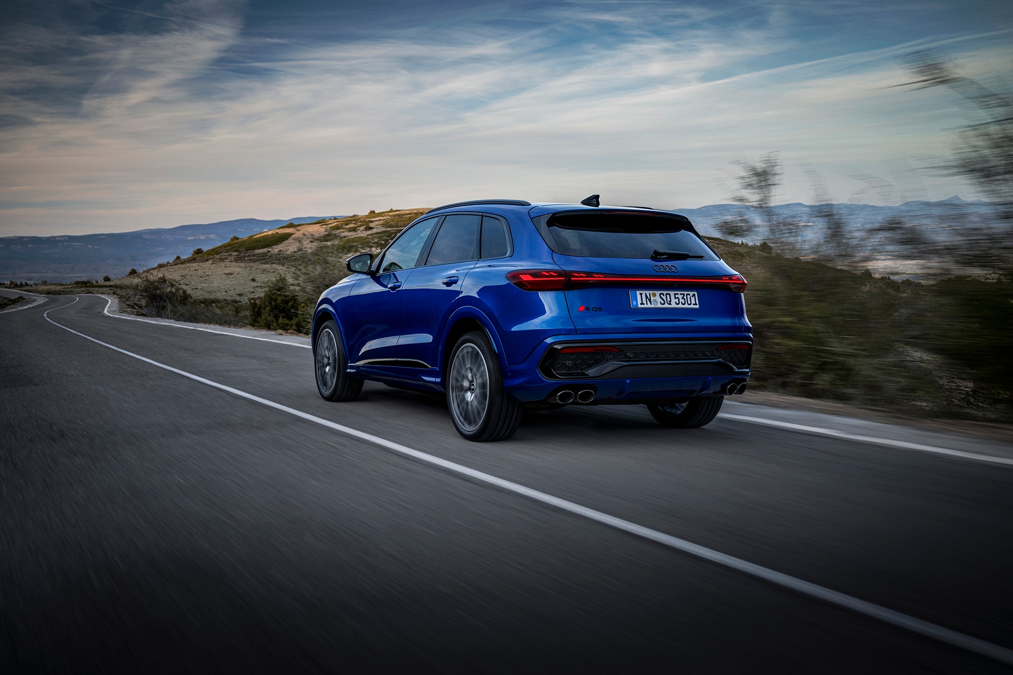 2025 Audi SQ5 in blue driving on road, rear