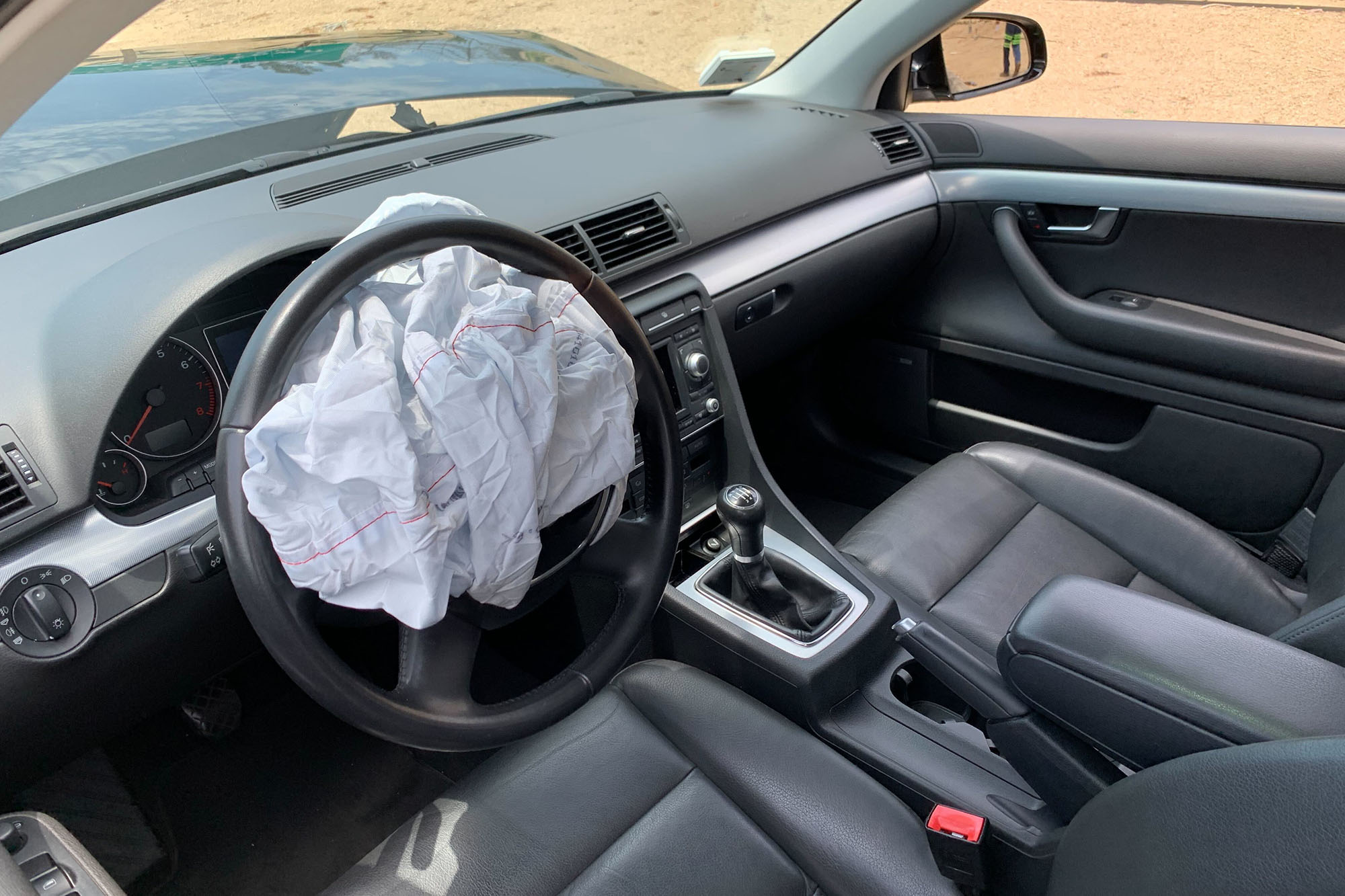 Interior of vehicle with the airbag deployed and deflated on the steering wheel.