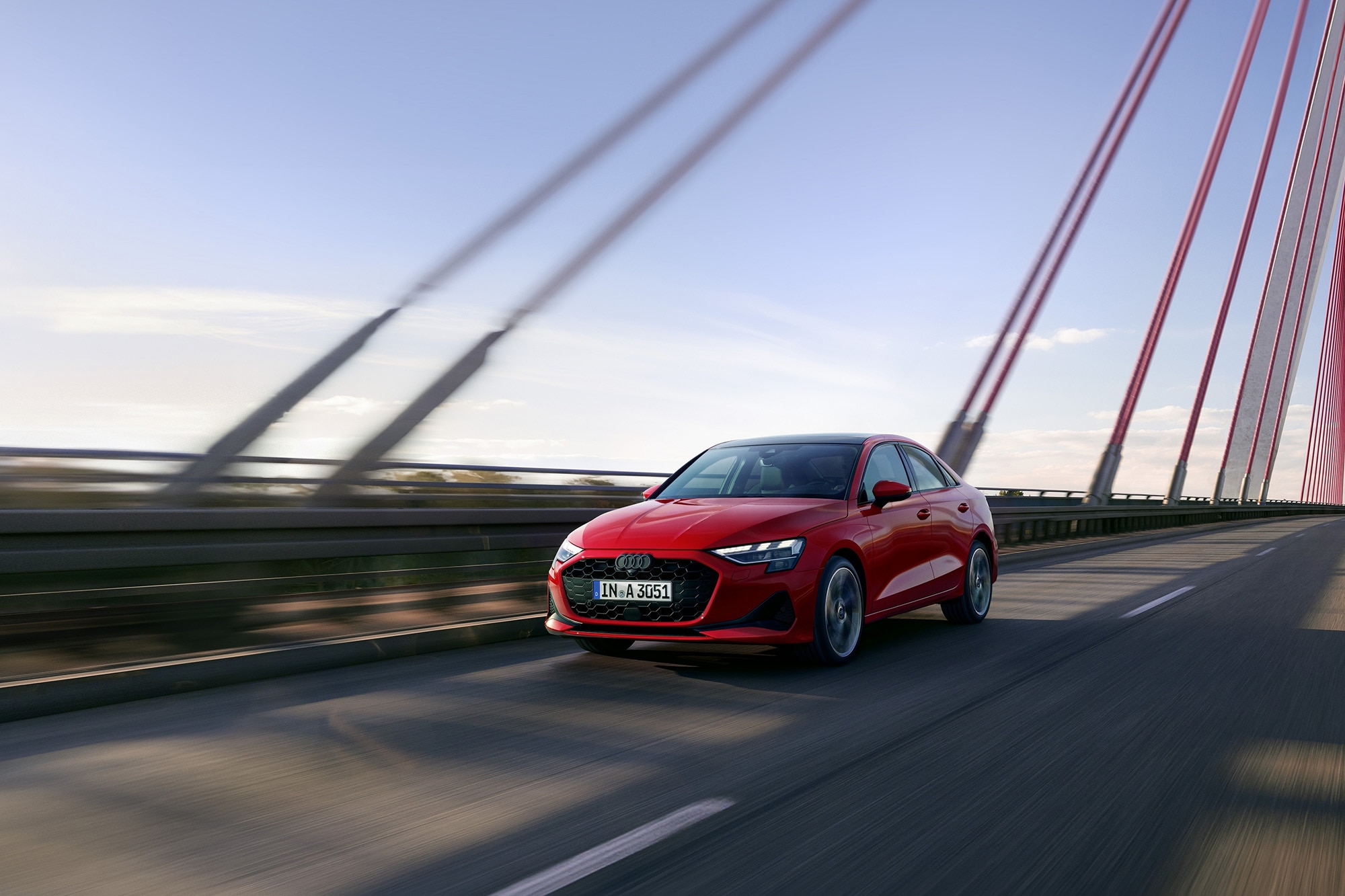 2025 Audi A3 in red driving on a suspension bridge