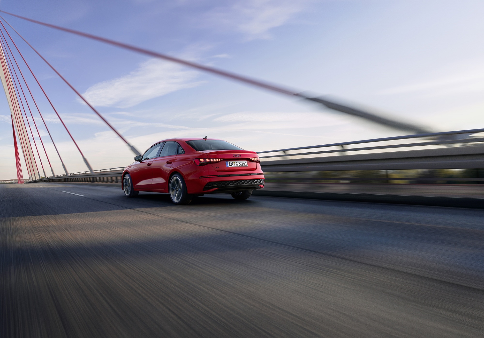 2025 Audi A3 in red driving on a suspension bridge, rear view