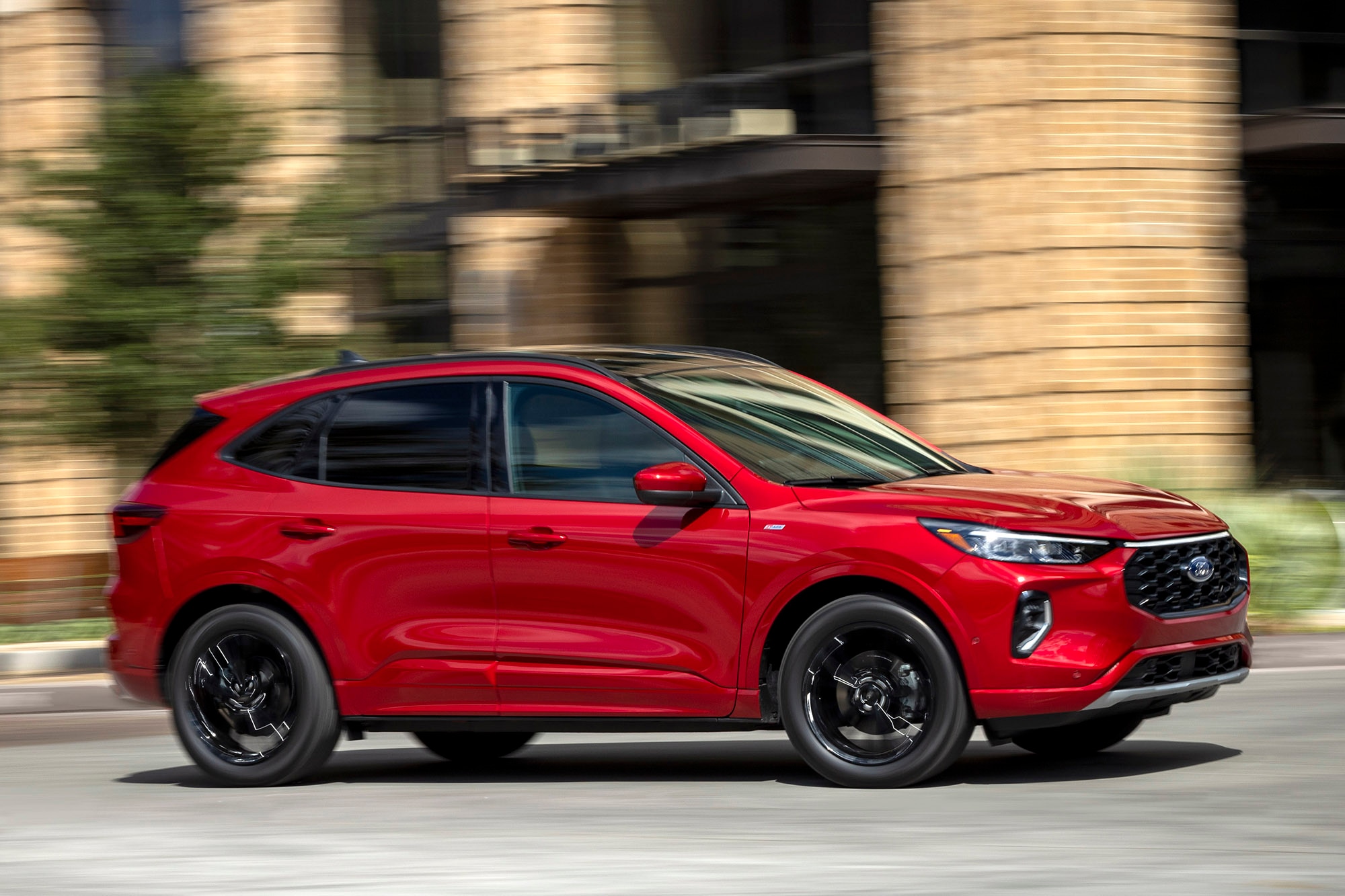 A red Ford Escape driving in an urban environment.