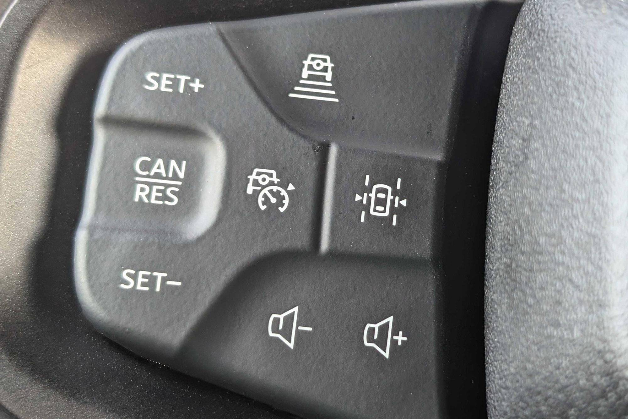 Steering wheel-mounted adaptive cruise control buttons.