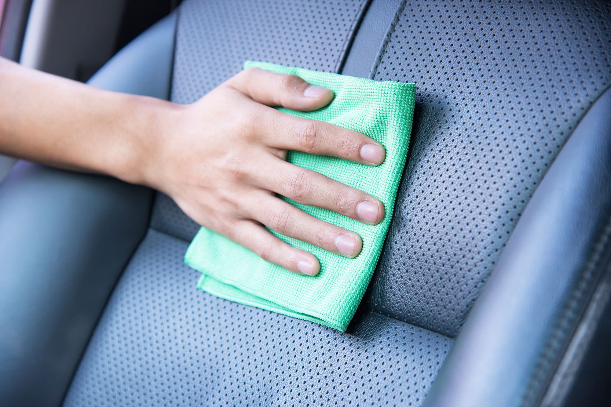 Perforated blue upholstery with a green microfiber cloth