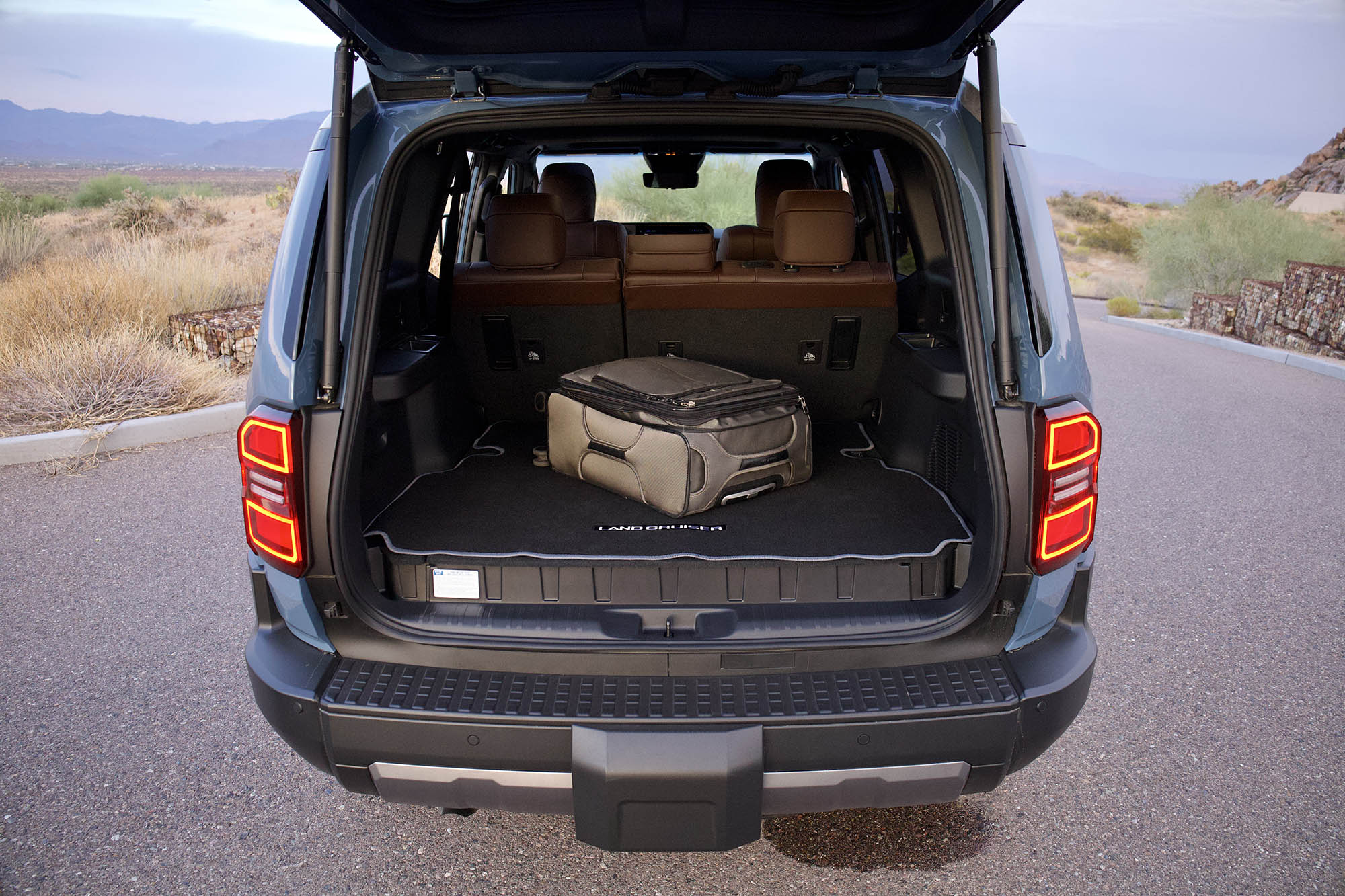 Cargo area of a Toyota Land Cruiser with a suitcase placed inside.