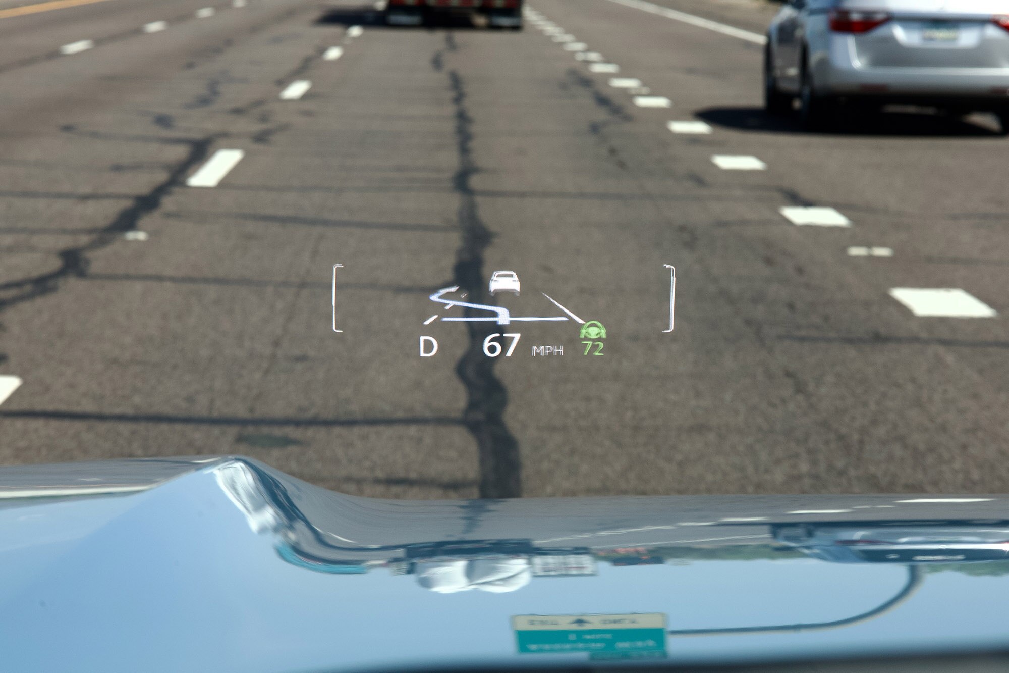 Head-up display inside a Toyota Land Cruiser driving on a paved road.