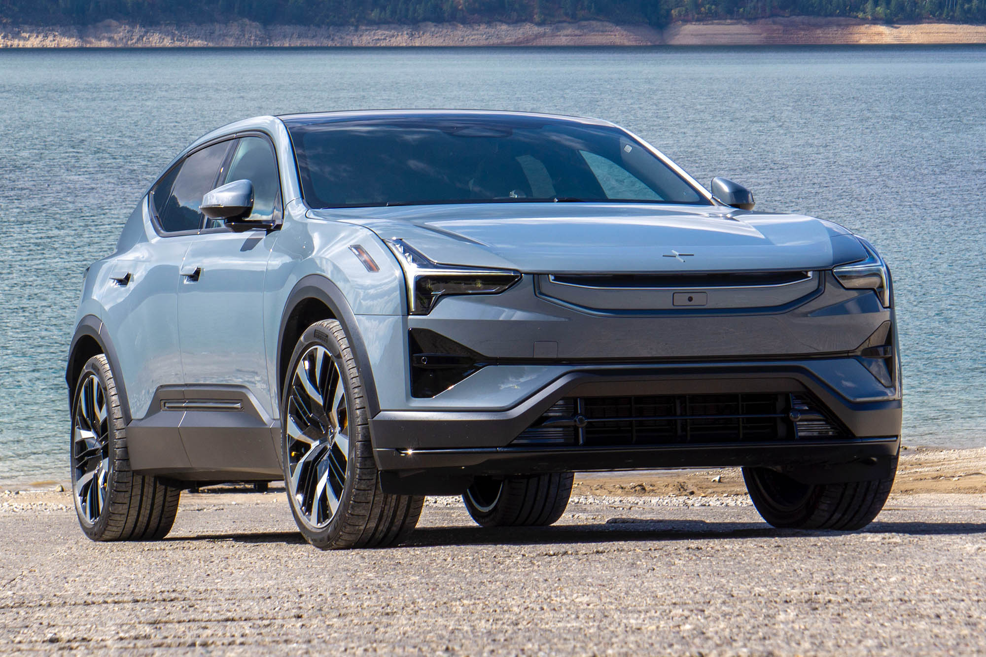 A gray 2025 Polestar 3 Launch Edition with a lake in the background.