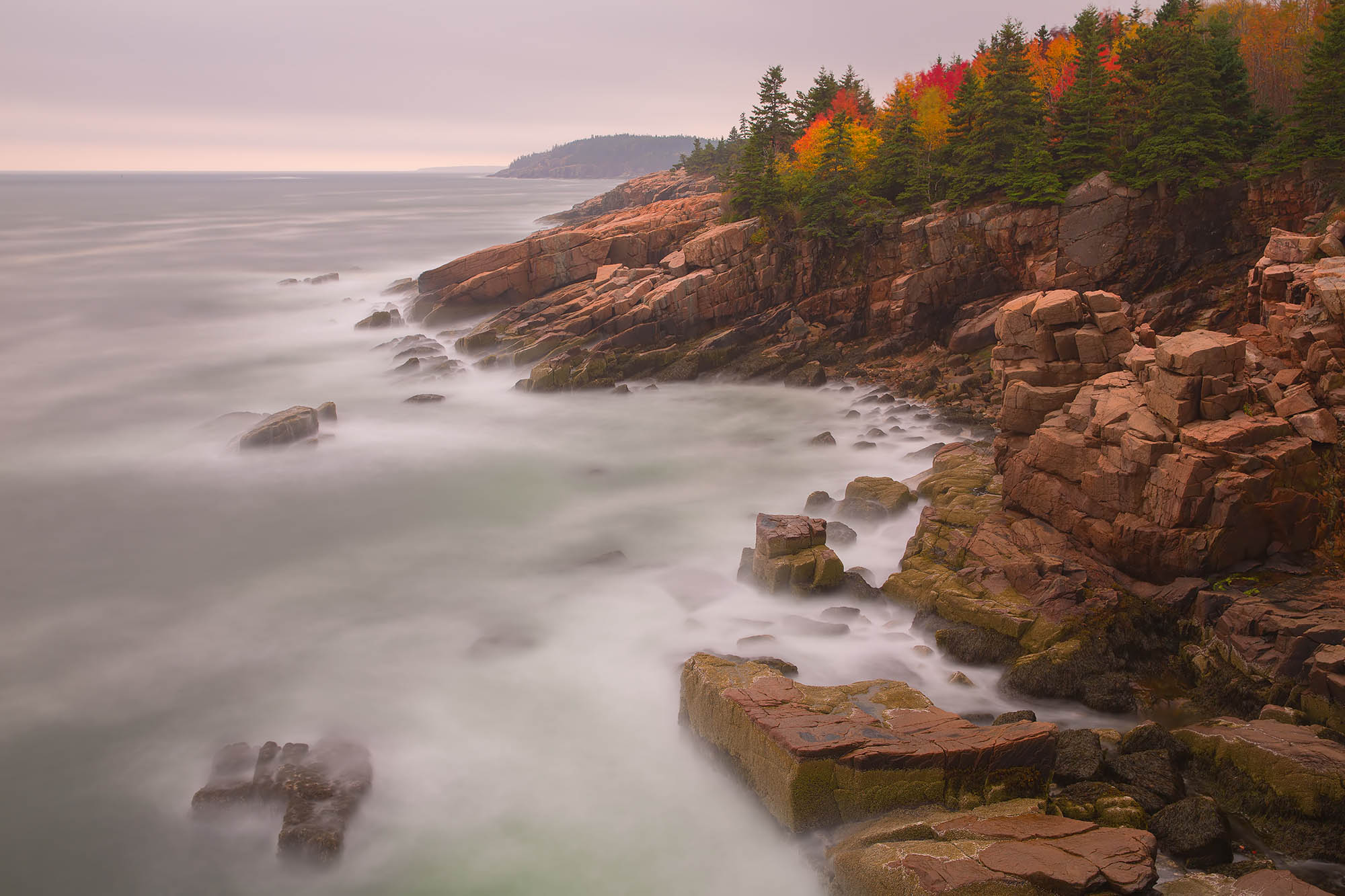 Mist rising off water near the rocks of Acadia National Park in Maine.