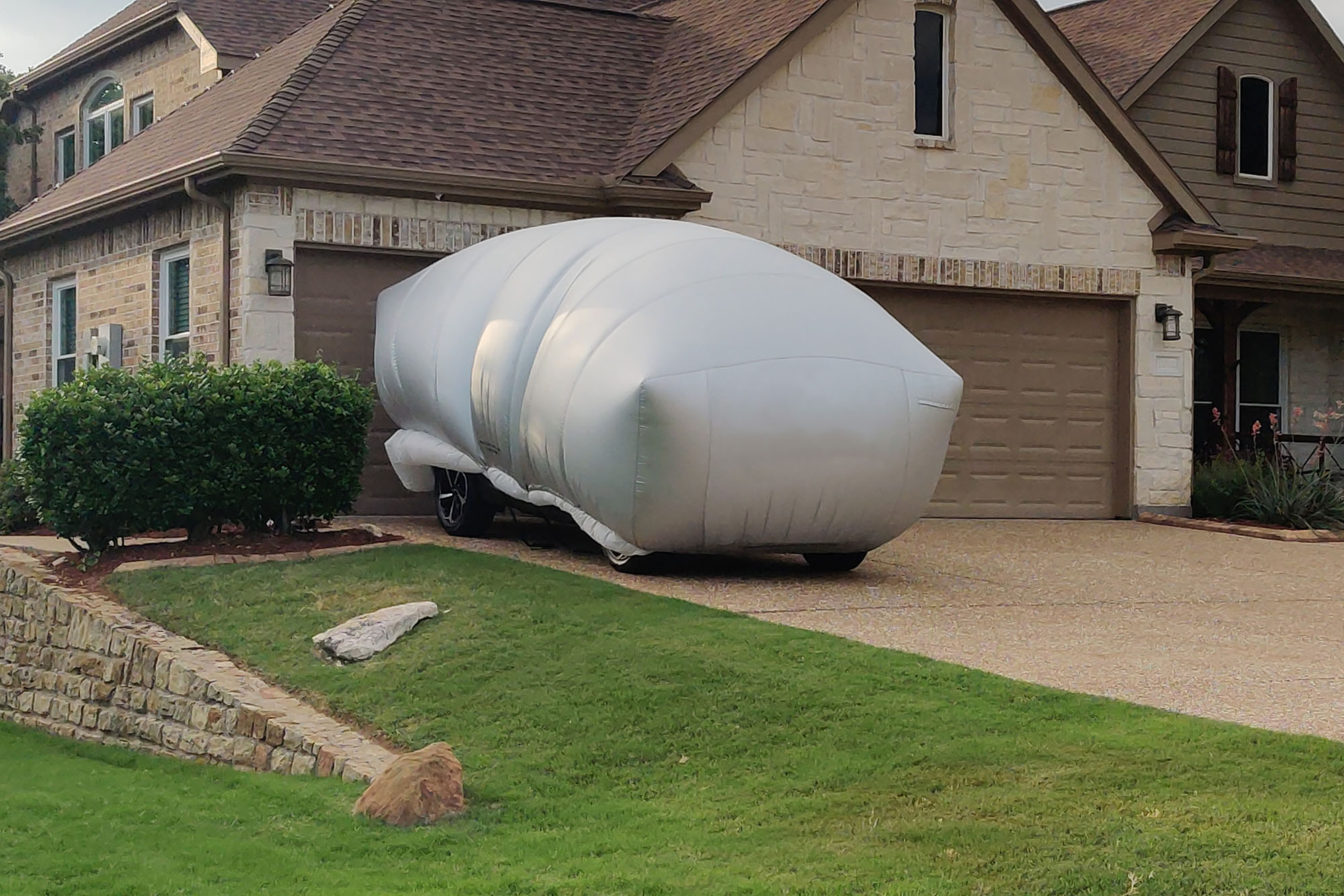 An car covered by an inflatable cover in a driveway